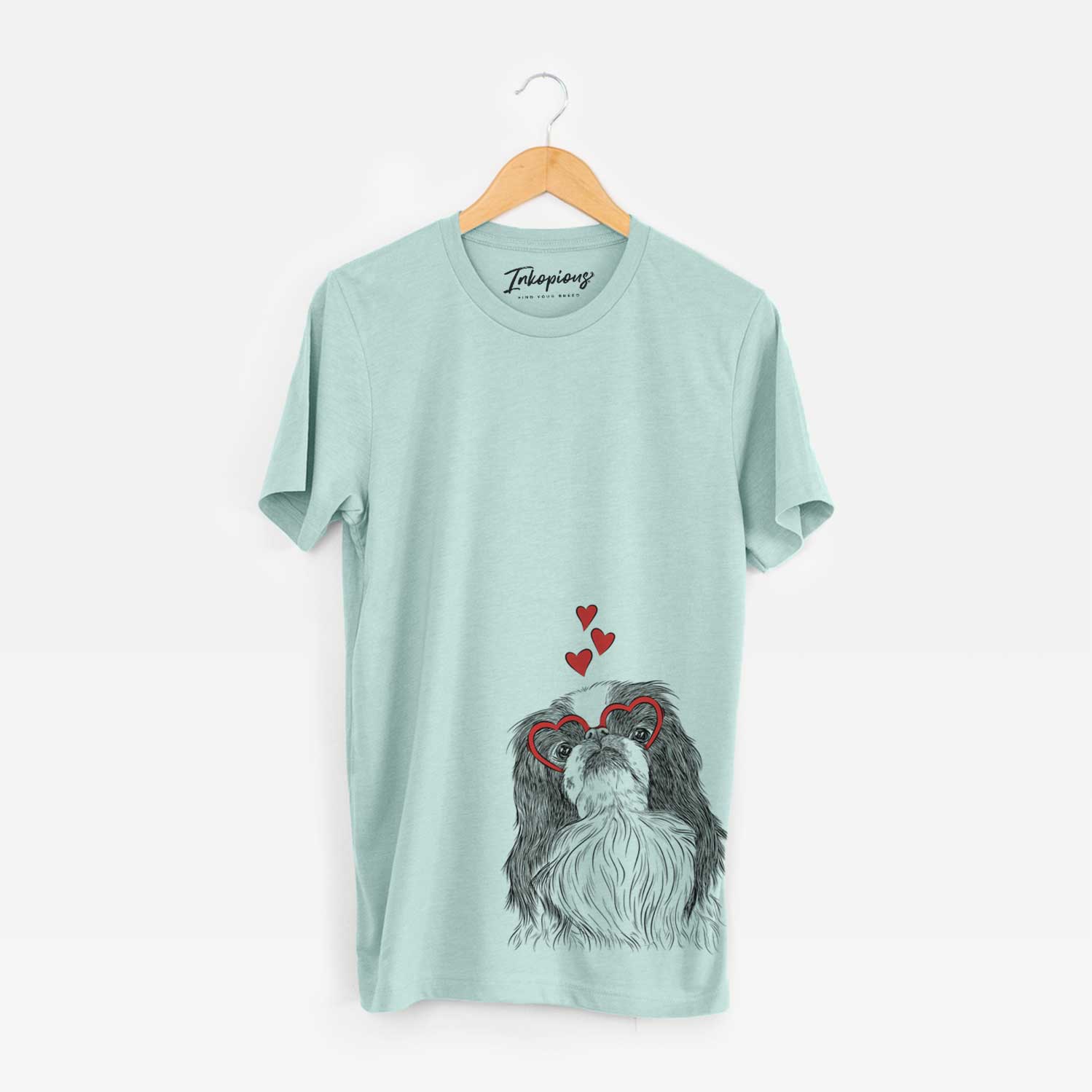 Hand-drawn sketch of Suki the Japanese Chin wearing heart-shaped glasses on a Heather Sage Unisex crewneck