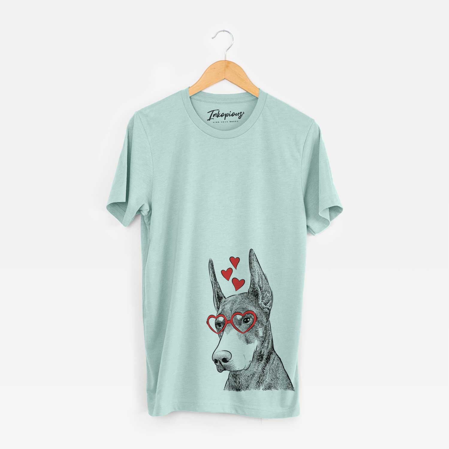 Hand-drawn sketch of Sunny the Doberman Pinscher wearing heart-shaped glasses on a Heather Sage Unisex crewneck