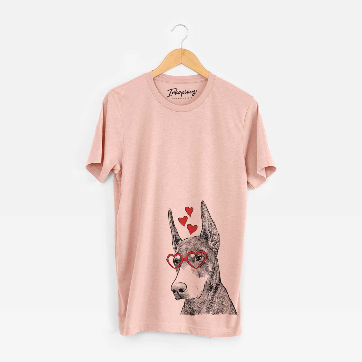 Hand-drawn sketch of Sunny the Doberman Pinscher wearing heart-shaped glasses on a Peach Unisex crewneck