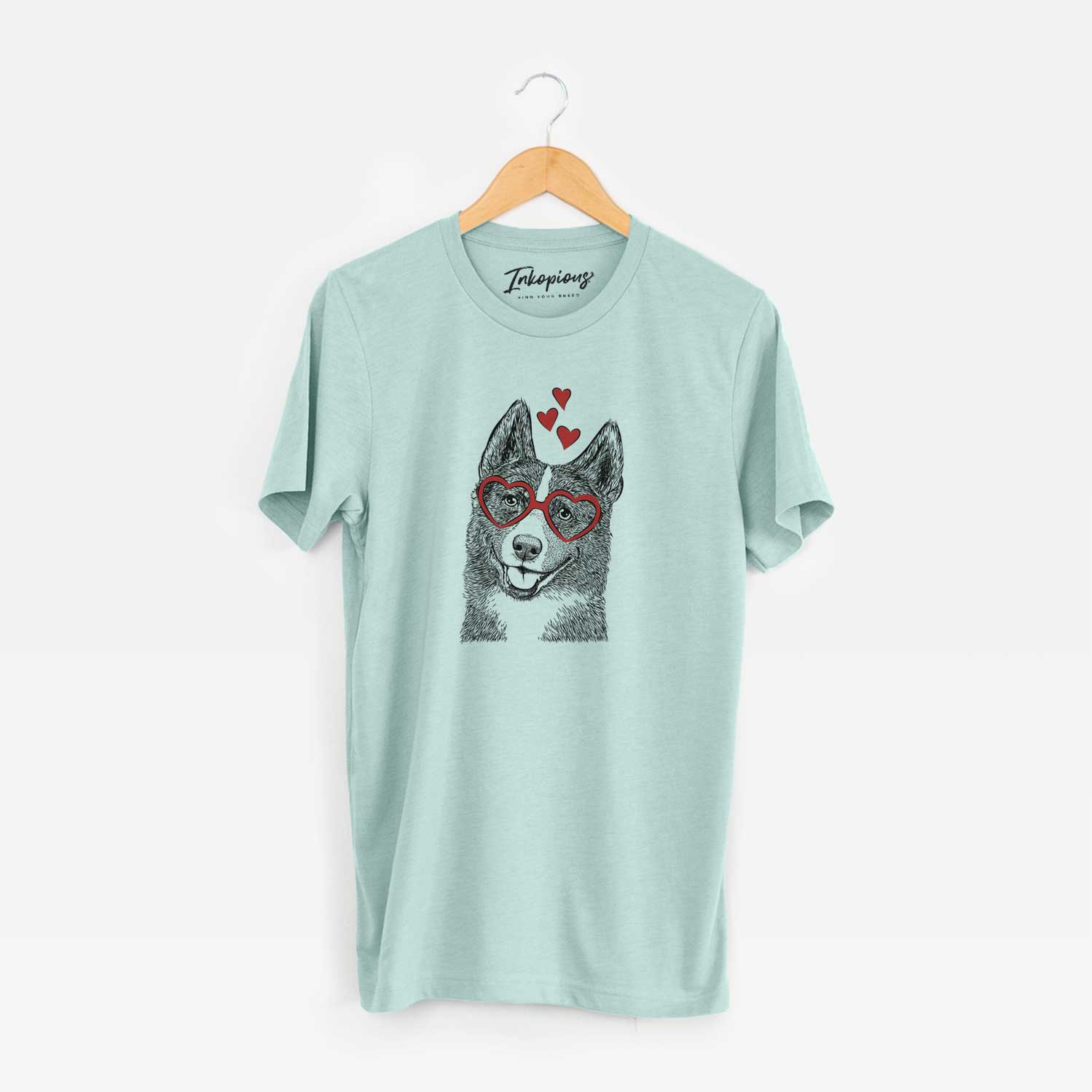 Hand-drawn sketch of Tosca the Karelian Bear Dog wearing heart-shaped glasses on a Heather Sage Unisex crewneck