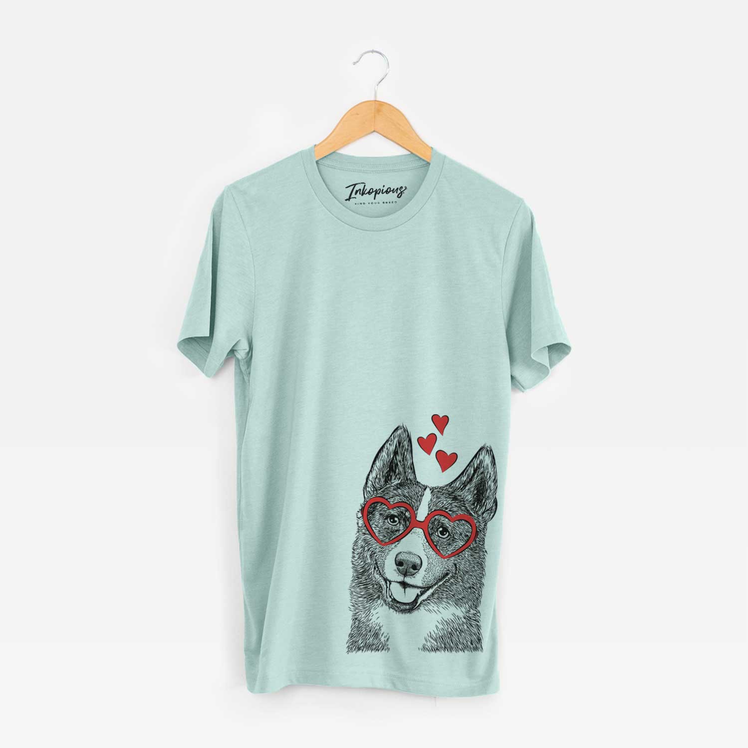 Hand-drawn sketch of Tosca the Karelian Bear Dog wearing heart-shaped glasses on a Heather Sage Unisex crewneck
