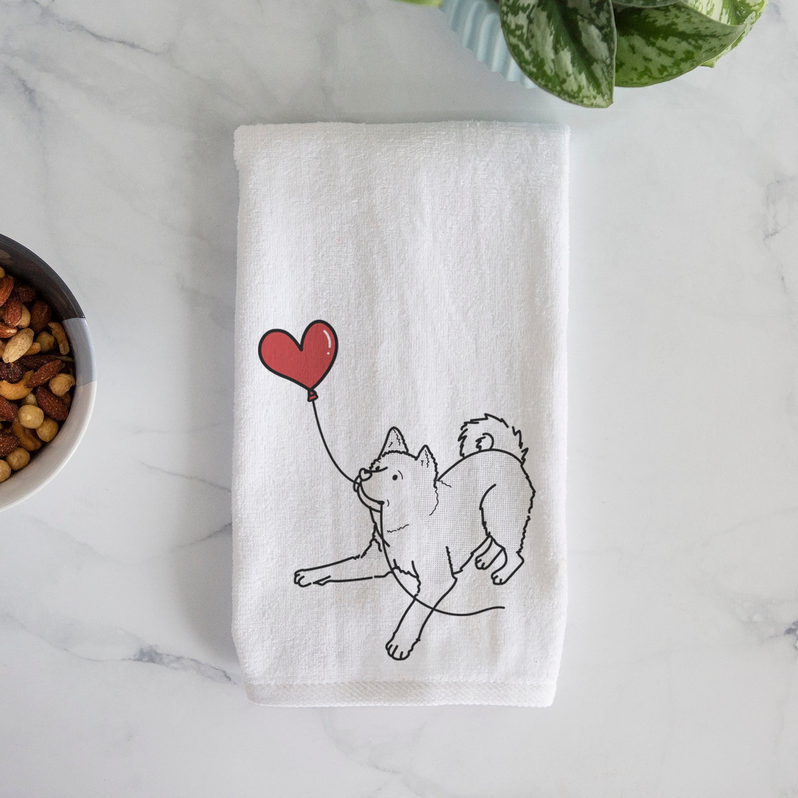 Minimalist line drawing of an Akita Heart String holding a heart balloon on a decorative hand towel