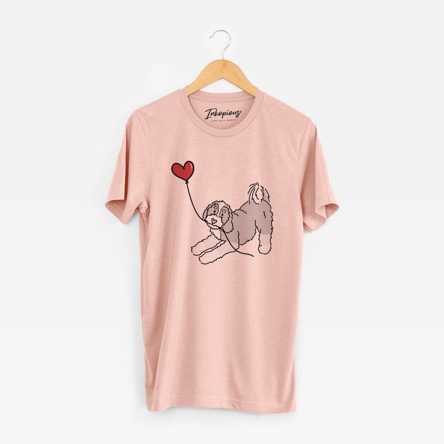 Minimalist line drawing of a Bernedoodle Heart String holding a heart balloon on a Peach Unisex crewneck