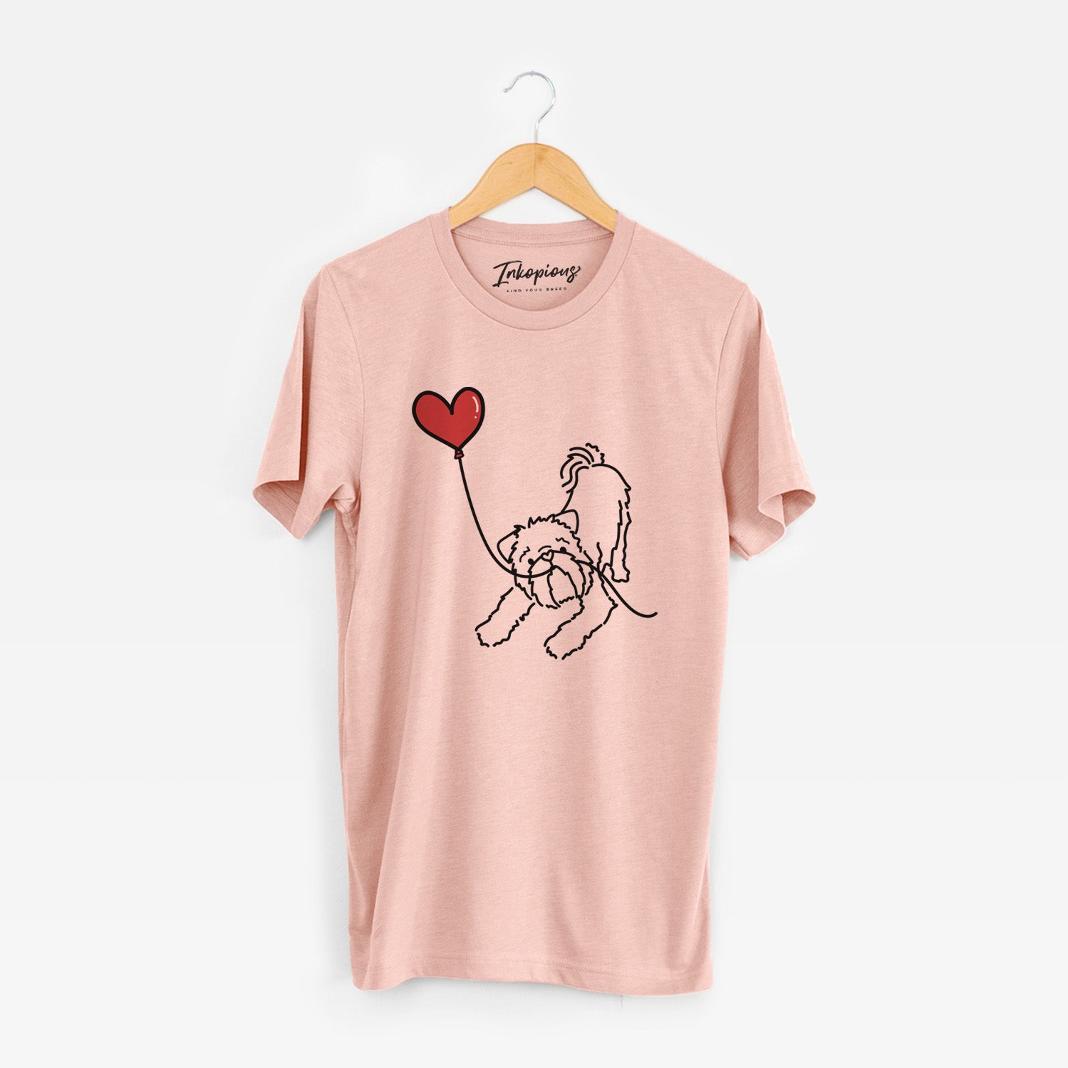 Minimalist line drawing of a Brussels Griffon Heart String holding a heart balloon on a Peach Unisex crewneck