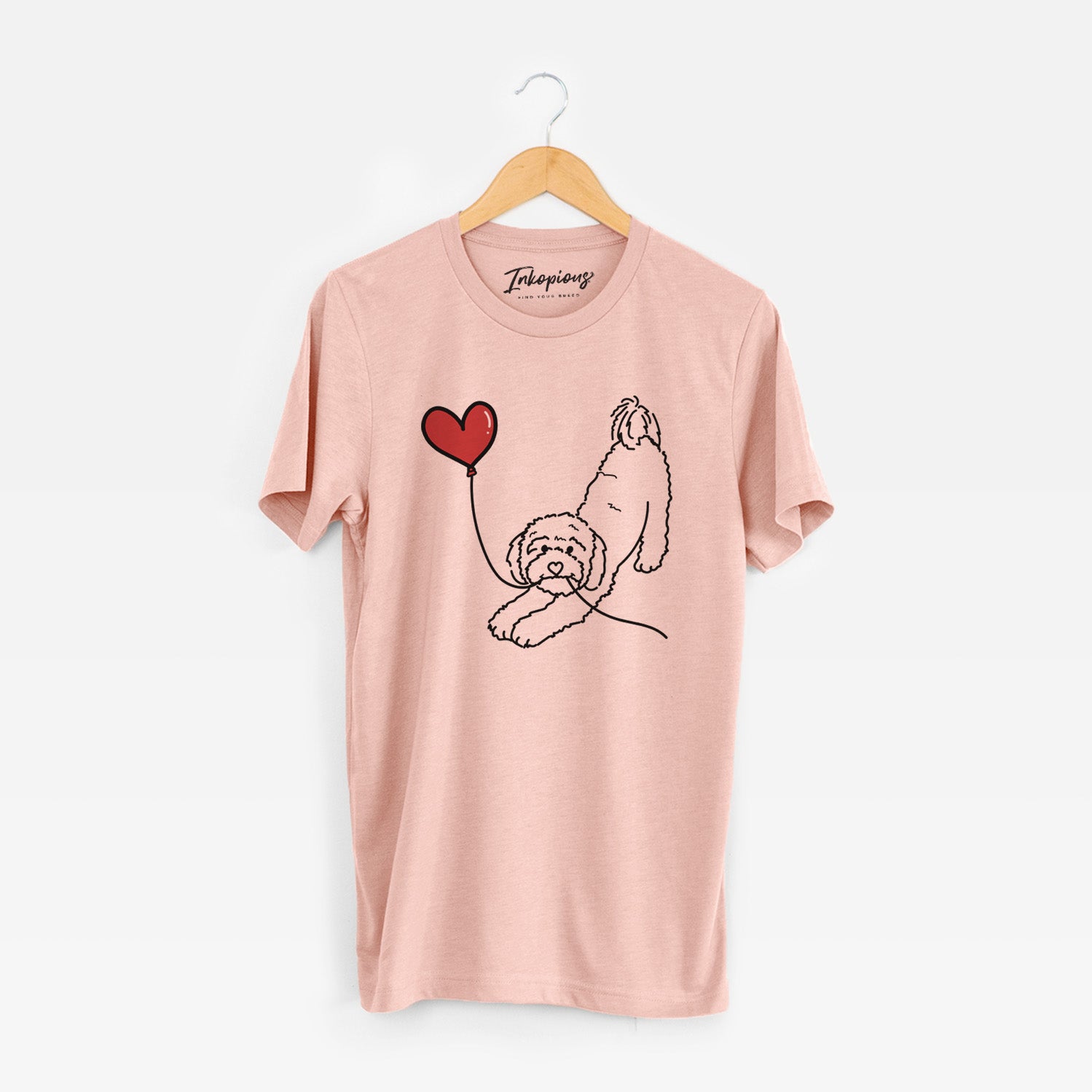 Minimalist line drawing of a Cavapoo Heart String holding a heart balloon on a Peach Unisex crewneck