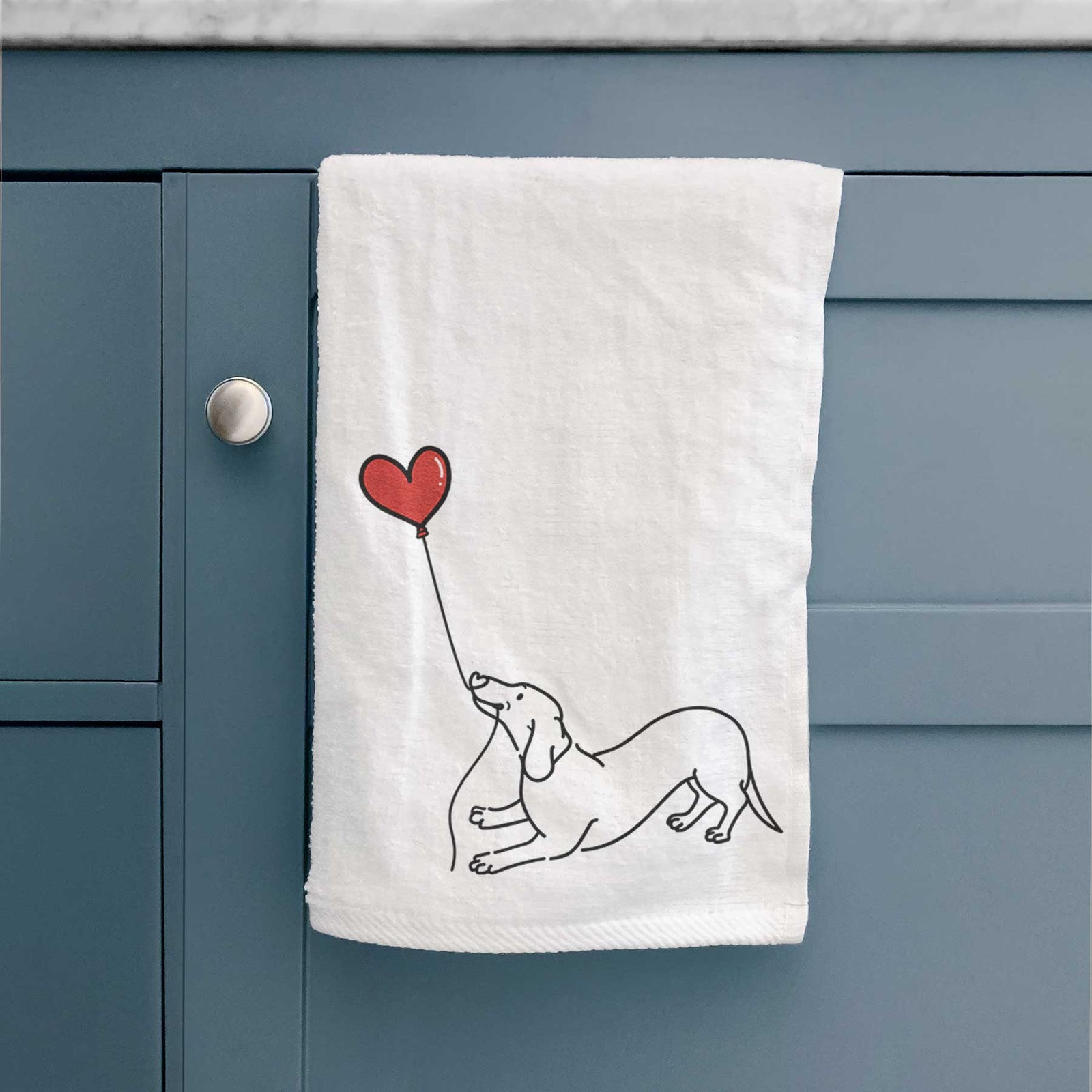 Minimalist line drawing of a Dachshund Heart String holding a heart balloon on a decorative hand towel
