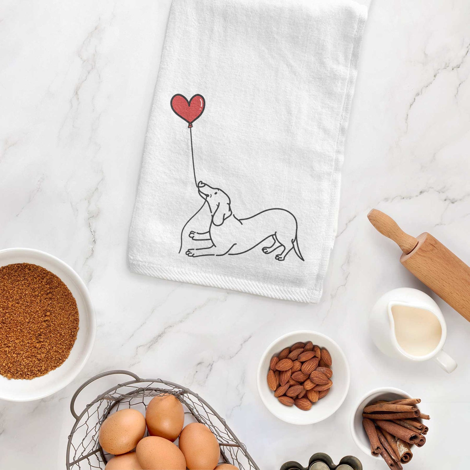 Minimalist line drawing of a Dachshund Heart String holding a heart balloon on a decorative hand towel