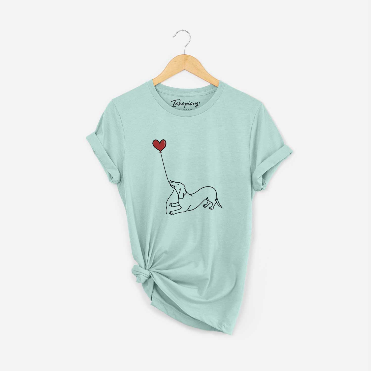 Minimalist line drawing of a Dachshund Heart String holding a heart balloon on a Heather Sage Unisex crewneck