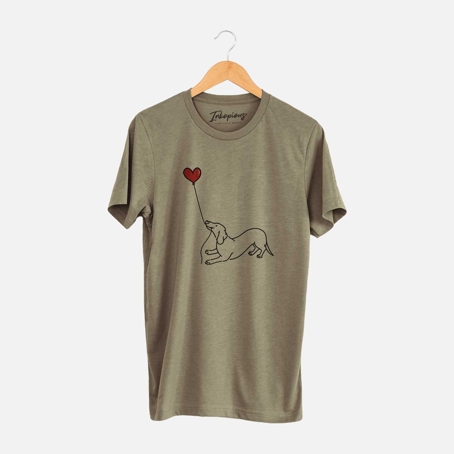 Minimalist line drawing of a Dachshund Heart String holding a heart balloon on an Olive Unisex crewneck