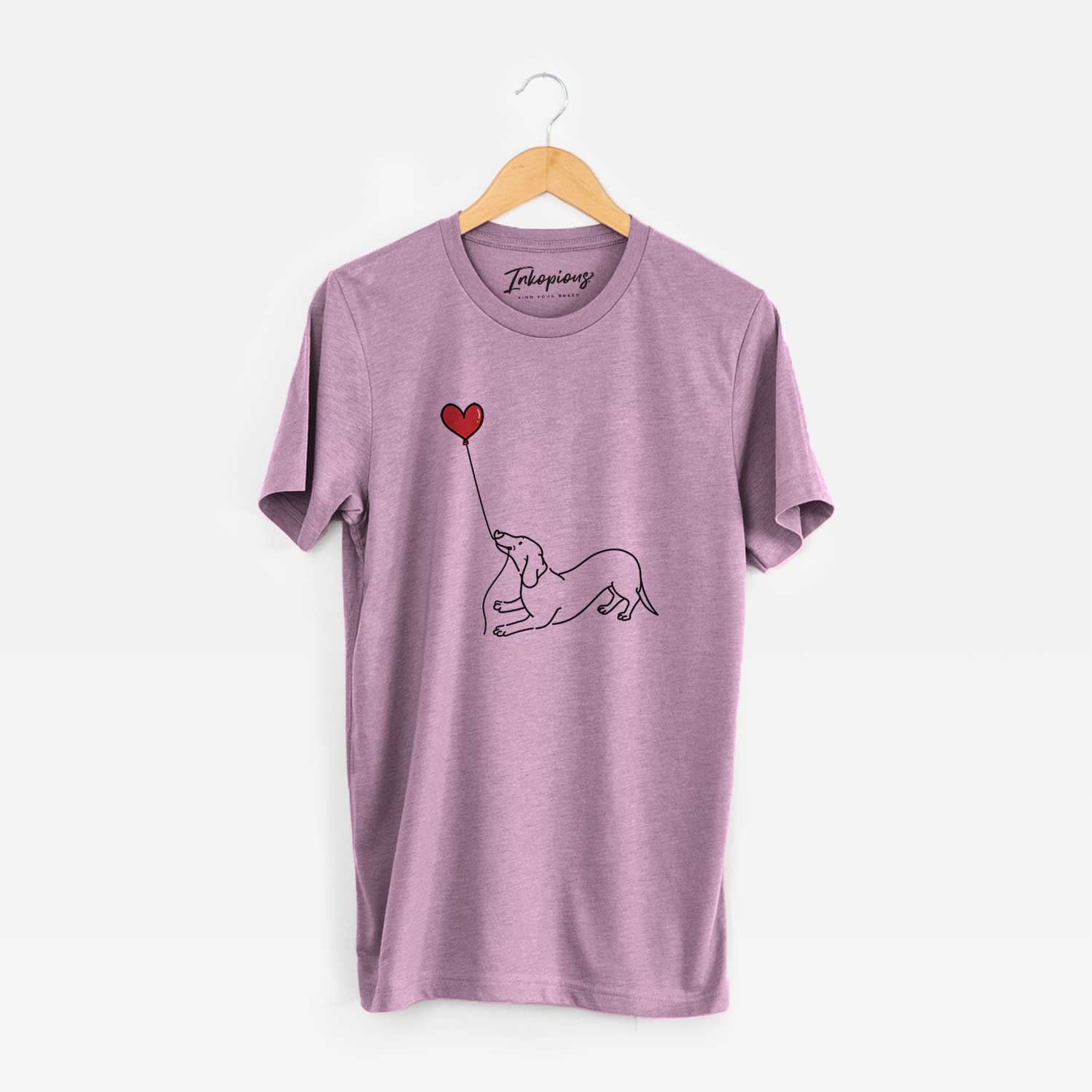Minimalist line drawing of a Dachshund Heart String holding a heart balloon on an Orchid Unisex crewneck