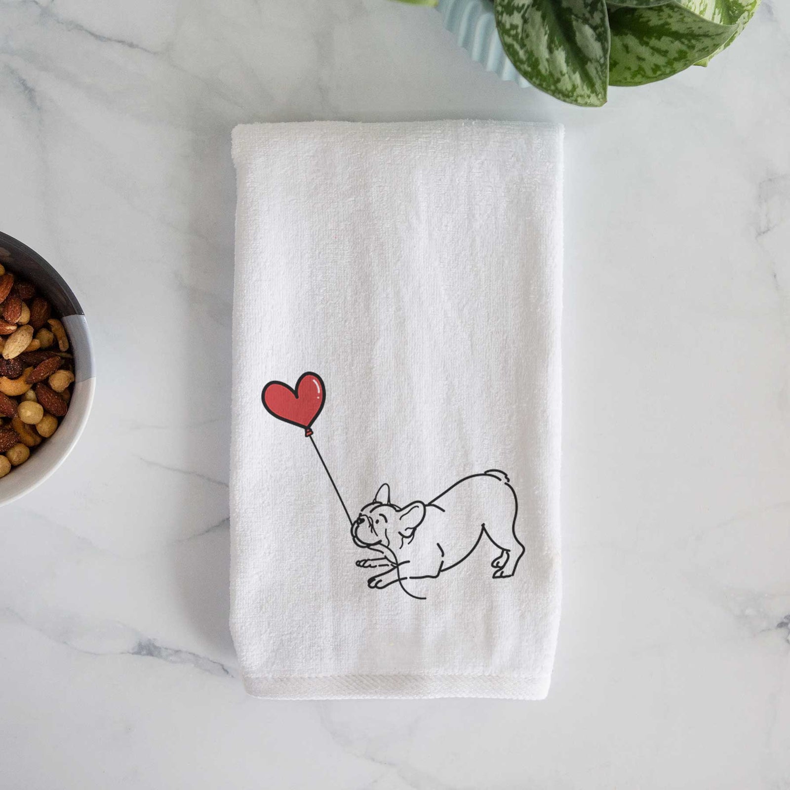 Minimalist line drawing of a Frenchie Heart String holding a heart balloon on a decorative hand towel