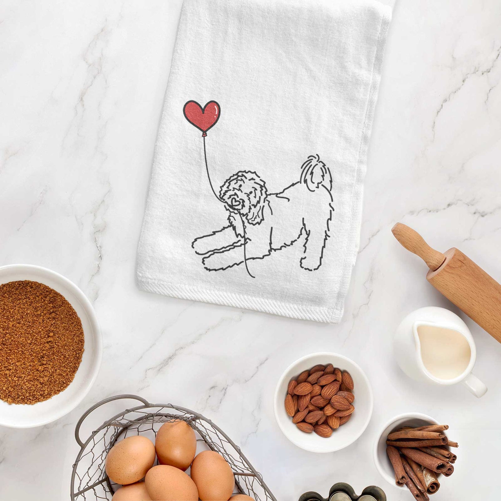 Minimalist line drawing of a Goldendoodle Heart String holding a heart balloon on a decorative hand towel
