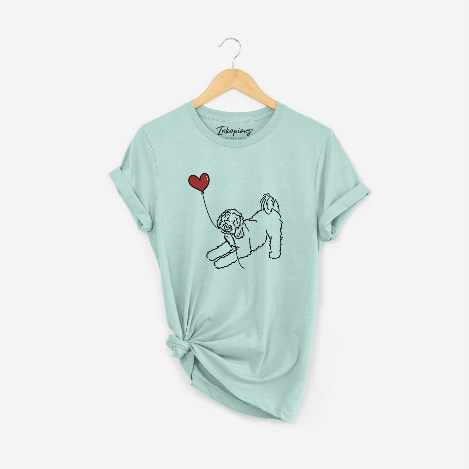 Minimalist line drawing of a Goldendoodle Heart String holding a heart balloon on a Heather Sage Unisex crewneck