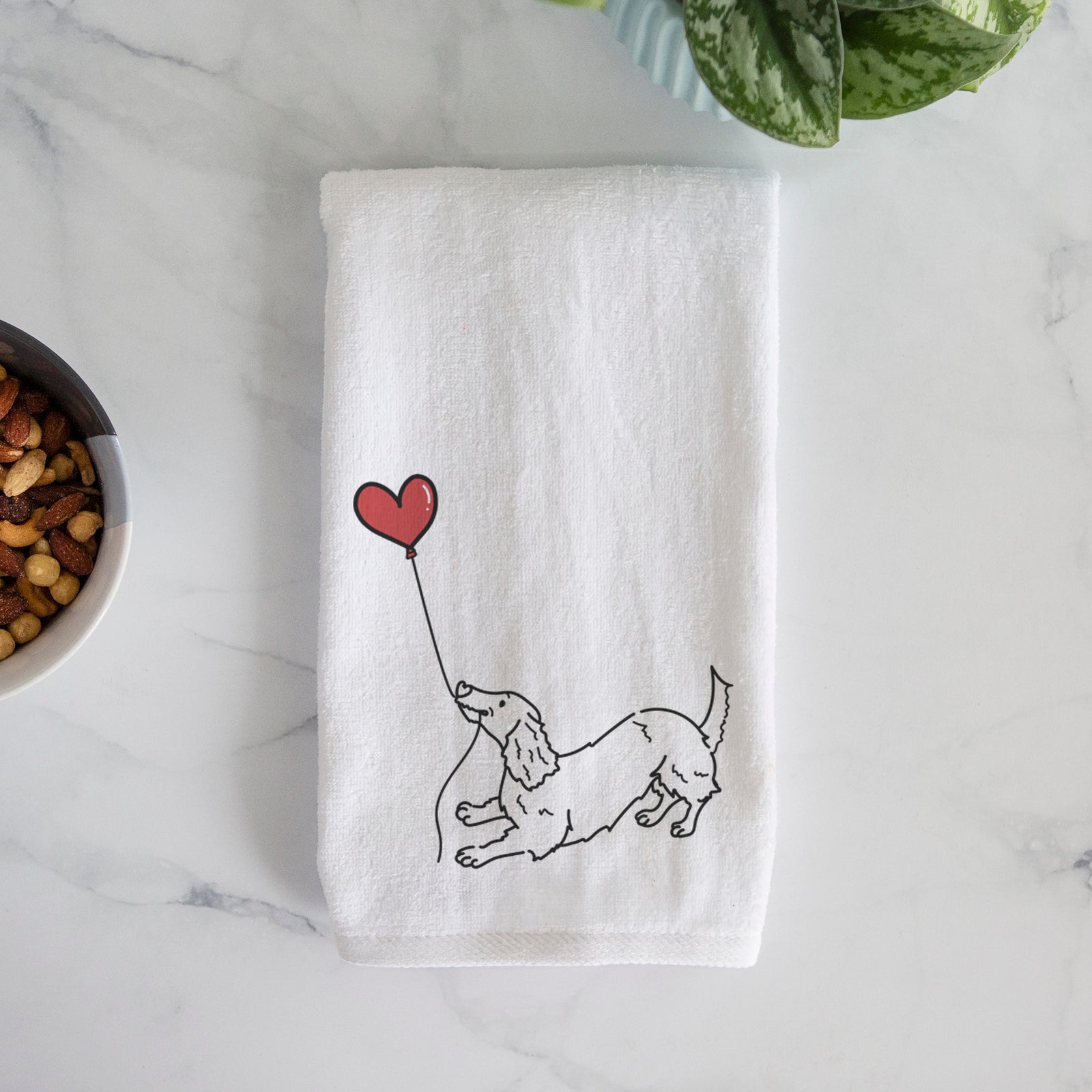 Minimalist line drawing of a Long Haired Dachshund Heart String holding a heart balloon on a decorative hand towel