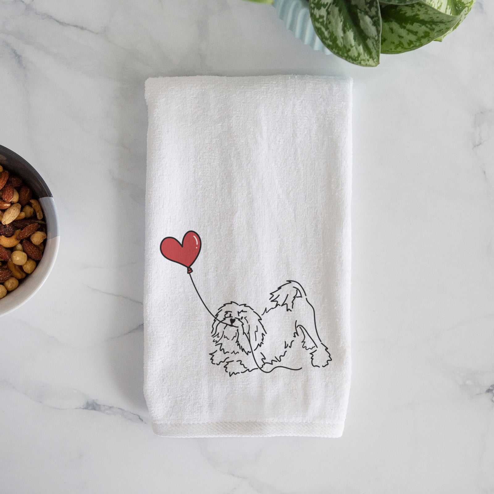 Minimalist line drawing of a Lowchen Heart String holding a heart balloon on a decorative hand towel