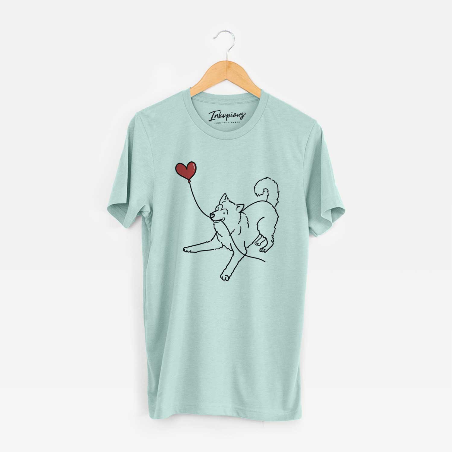 Minimalist line drawing of an Alaskan Malamute Heart String holding a heart balloon on a Heather Sage Unisex crewneck