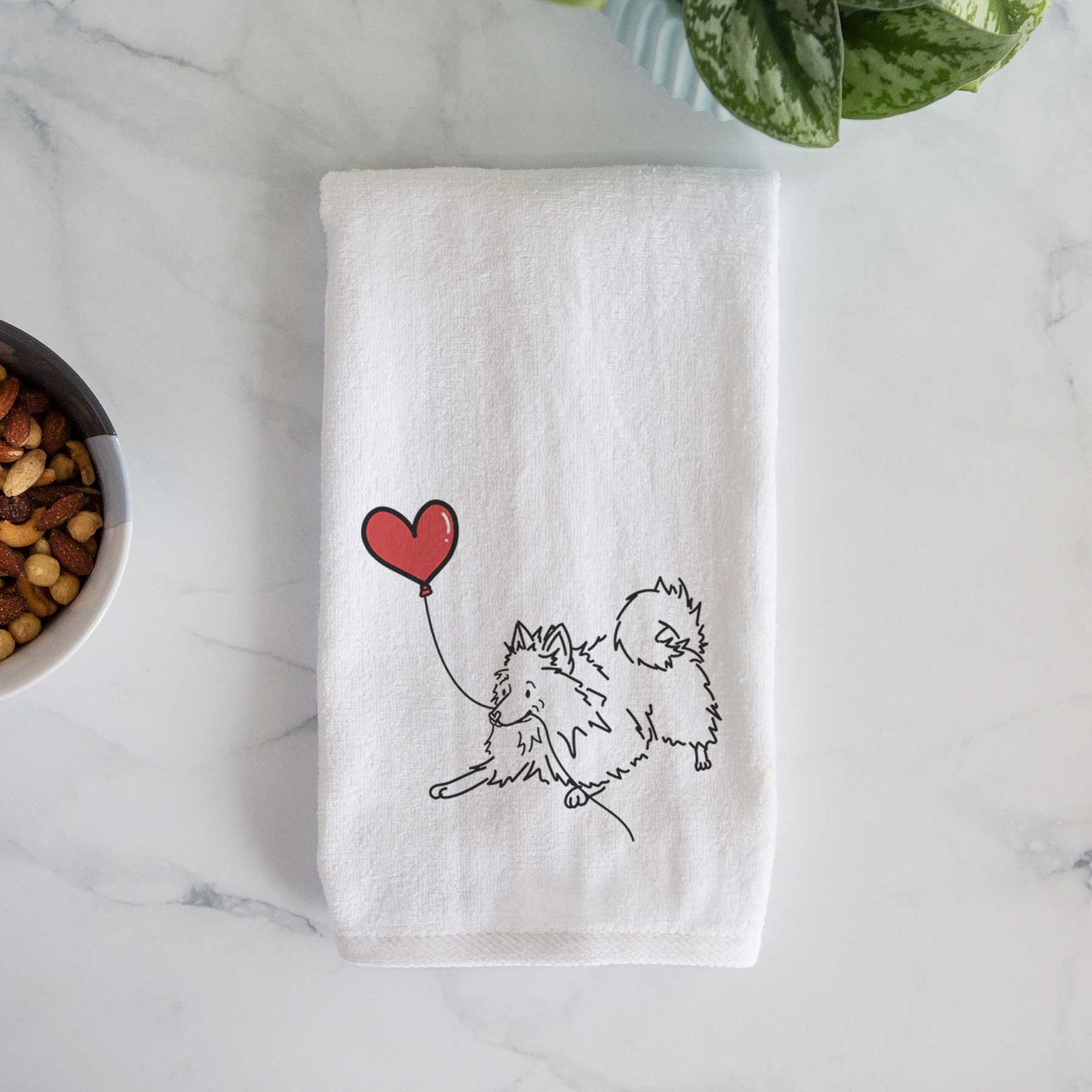 Minimalist line drawing of a Pomeranian Heart String holding a heart balloon on a decorative hand towel