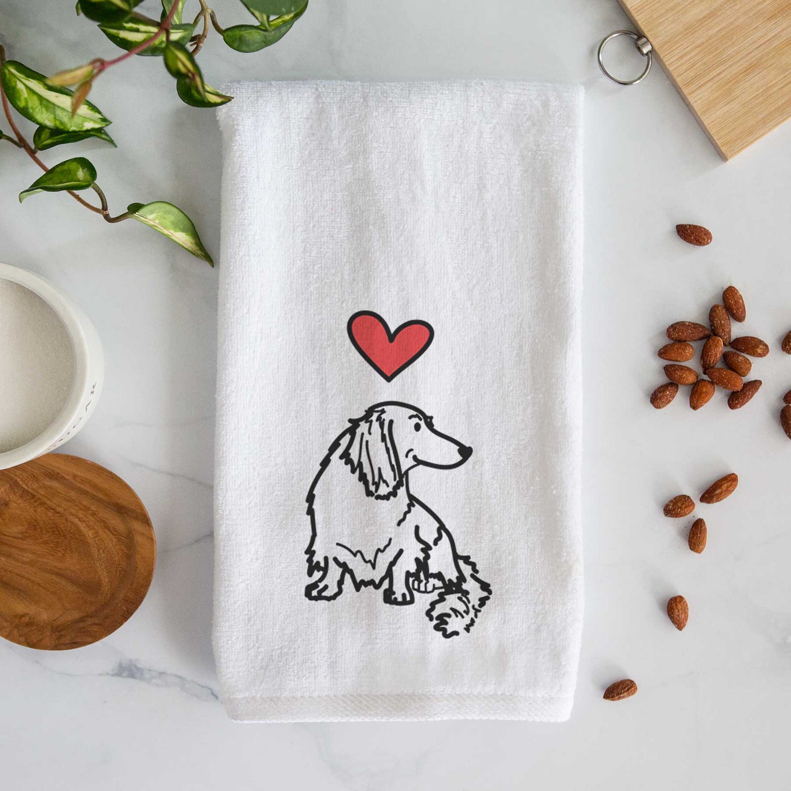 Minimalist line drawing of Bella the Dachshund with a red heart on a decorative hand towel