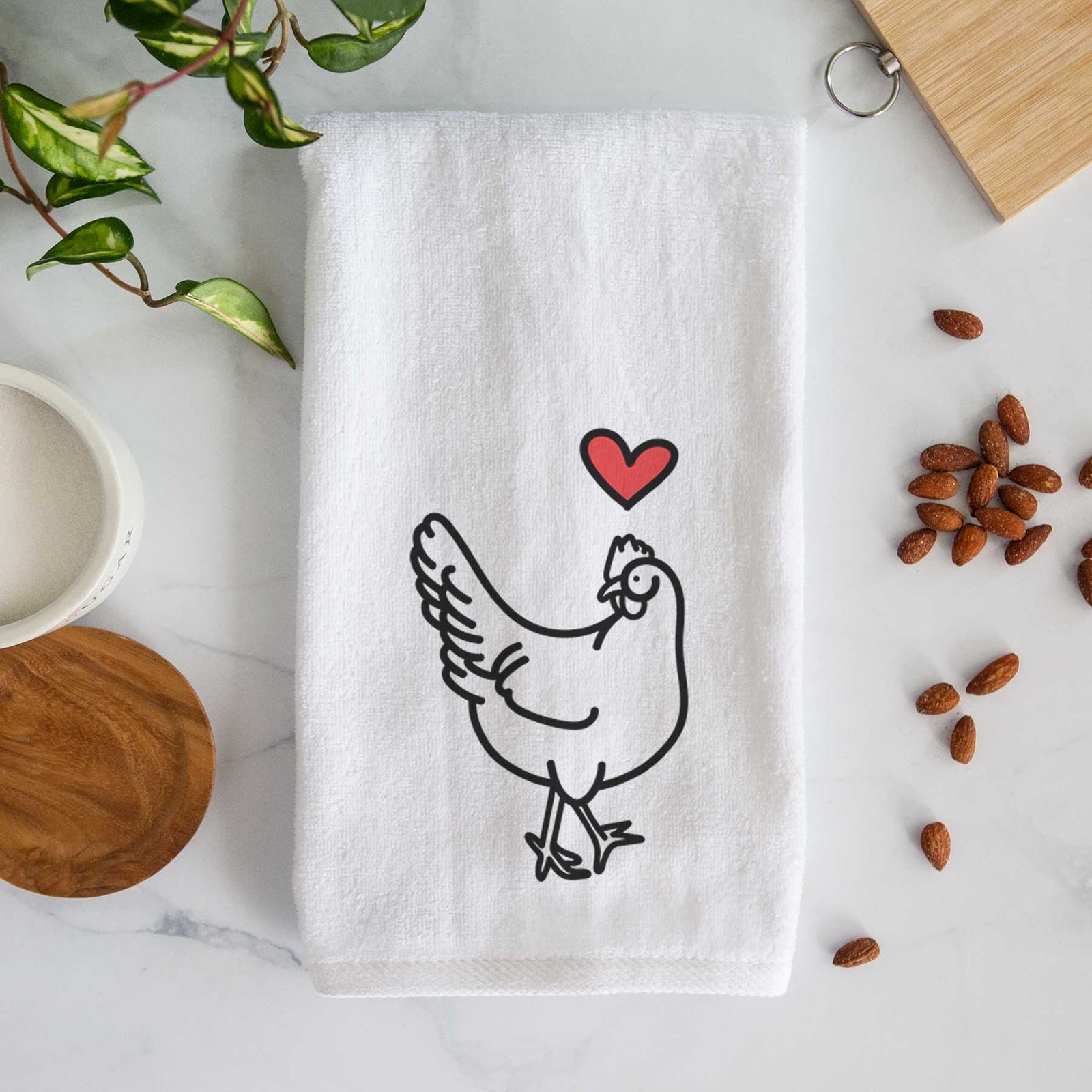 Minimalist line drawing of Daisy the Chicken with a red heart on a decorative hand towel