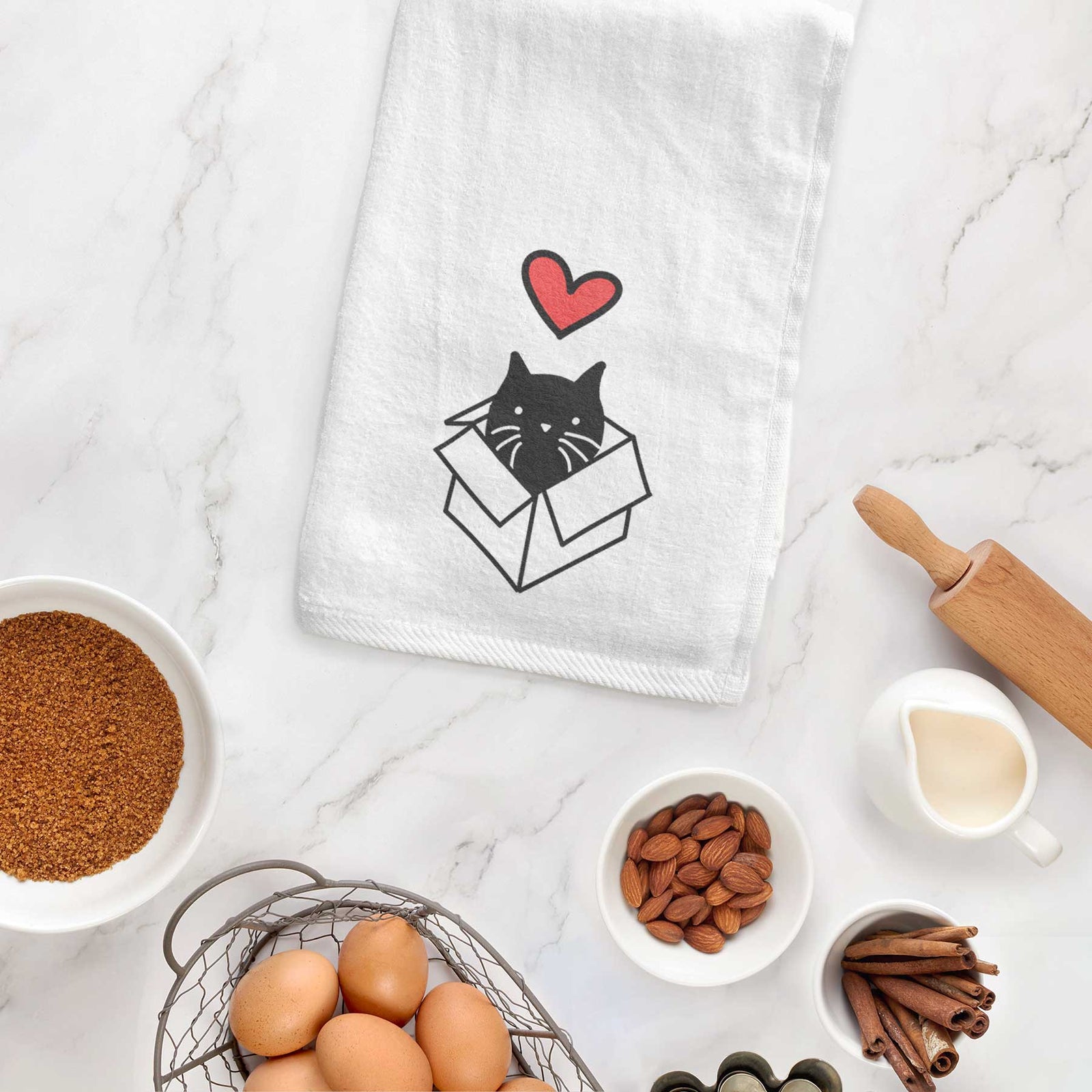 Minimalist line drawing of Doc the Black Cat in a Box with a red heart on a decorative hand towel