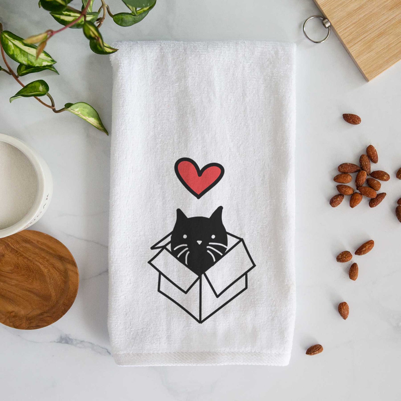 Minimalist line drawing of Doc the Black Cat in a Box with a red heart on a decorative hand towel