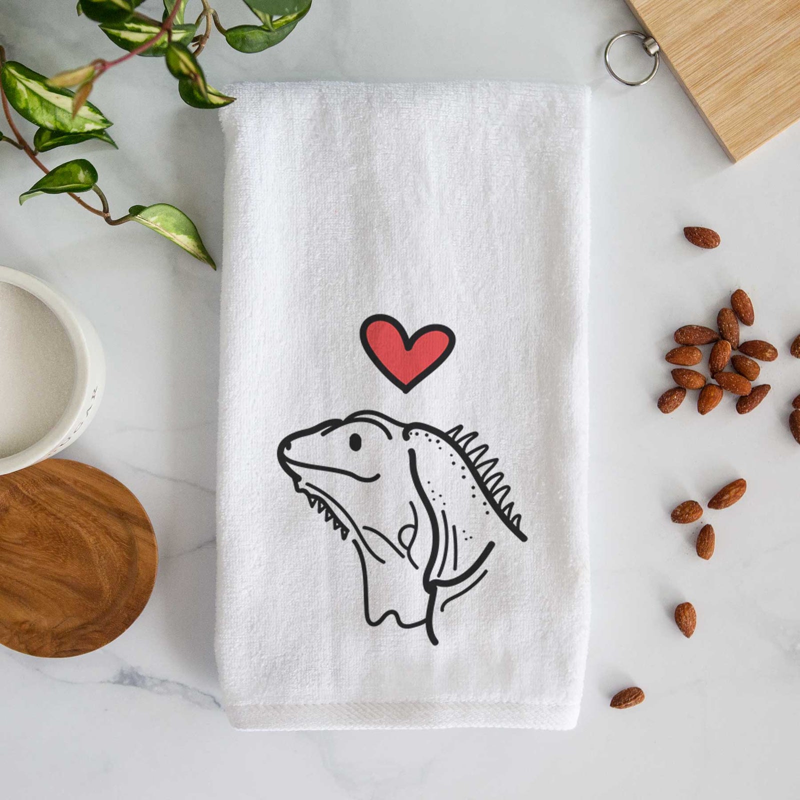 Minimalist line drawing of Louie the Iguana with a red heart on a decorative hand towel
