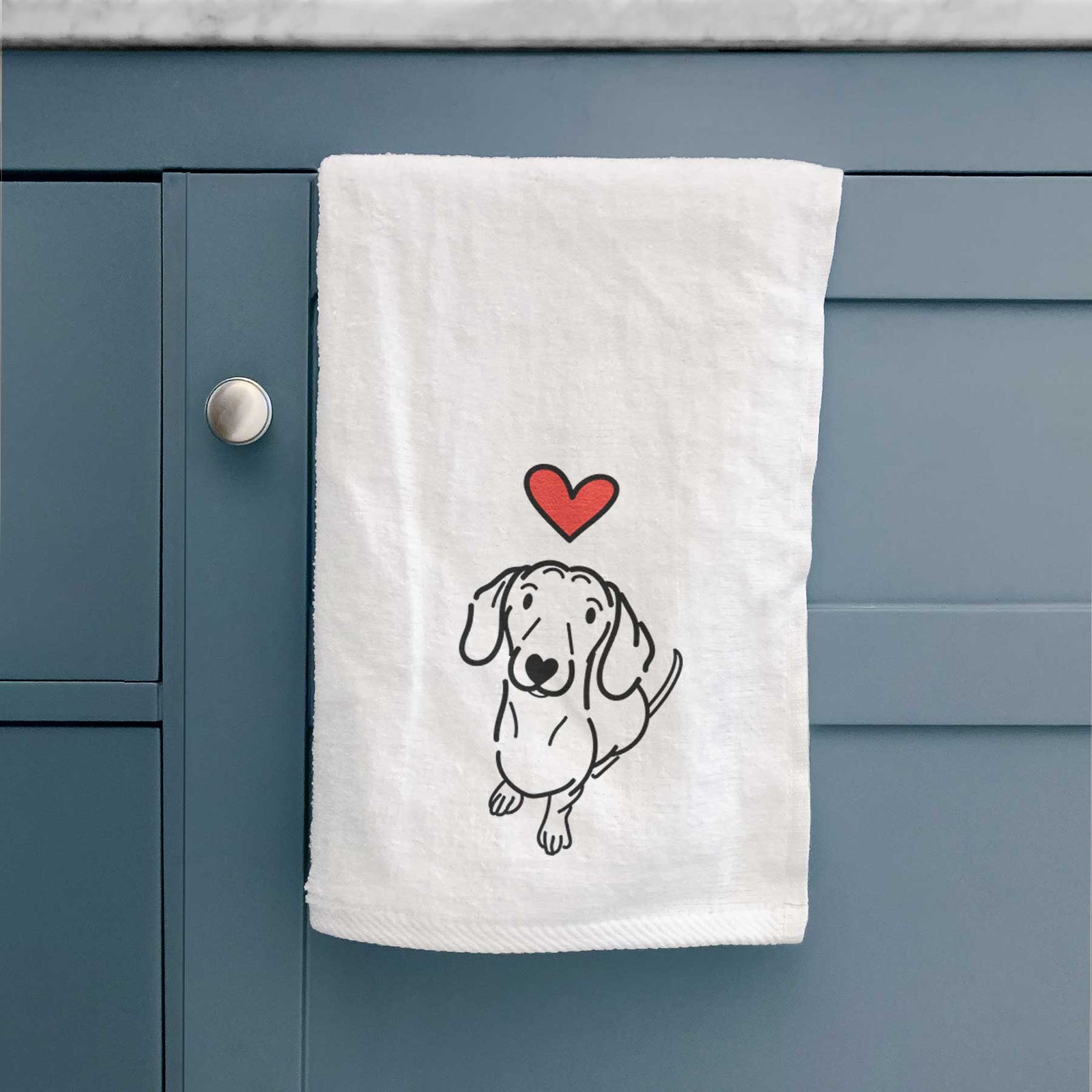 Minimalist line drawing of Moxie the Dachshund with a red heart on a decorative hand towel