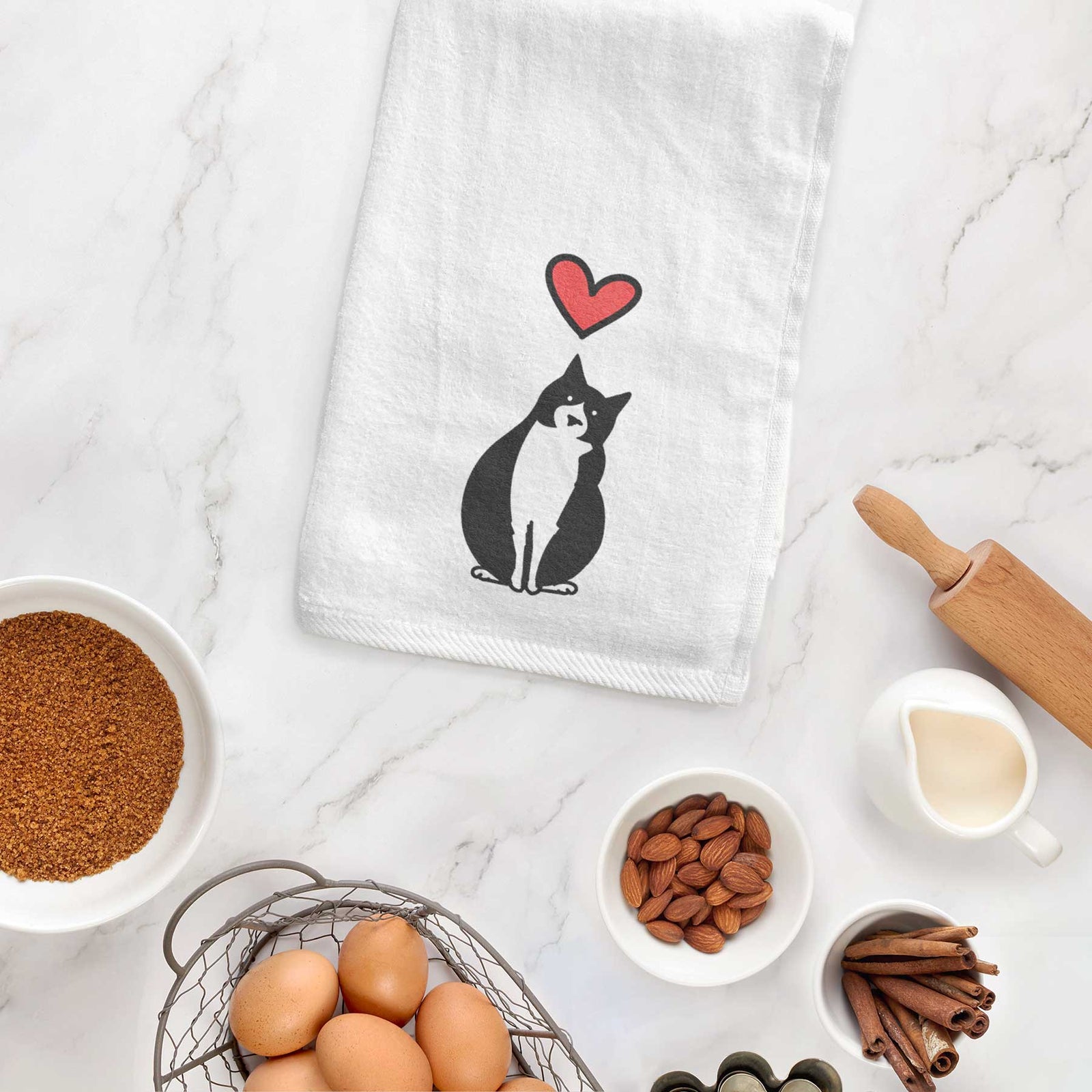 Minimalist line drawing of Oliver the Tuxedo Cat with a red heart on a decorative hand towel