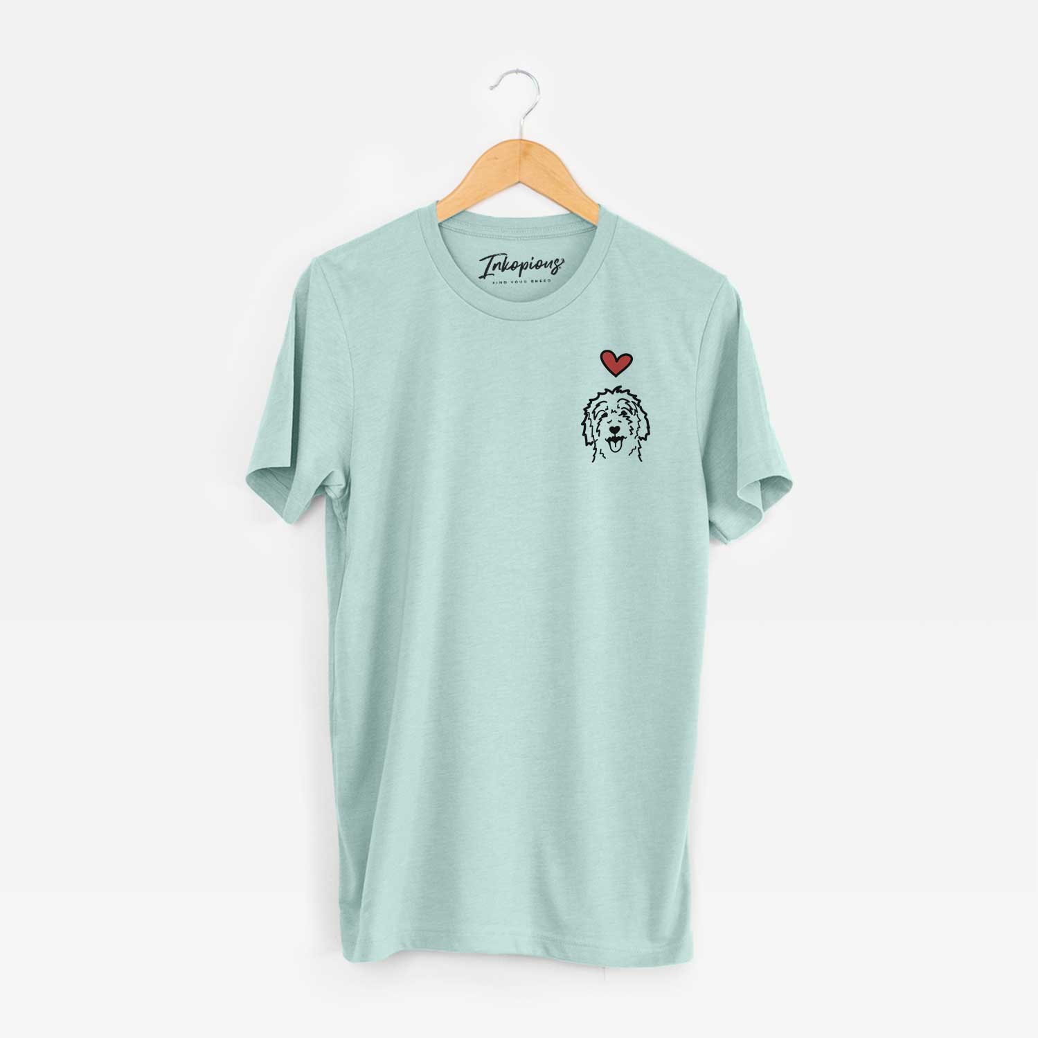 Small chest-pocket minimalist line drawing of a Goldendoodle with a red heart on a Heather Sage Unisex crewneck