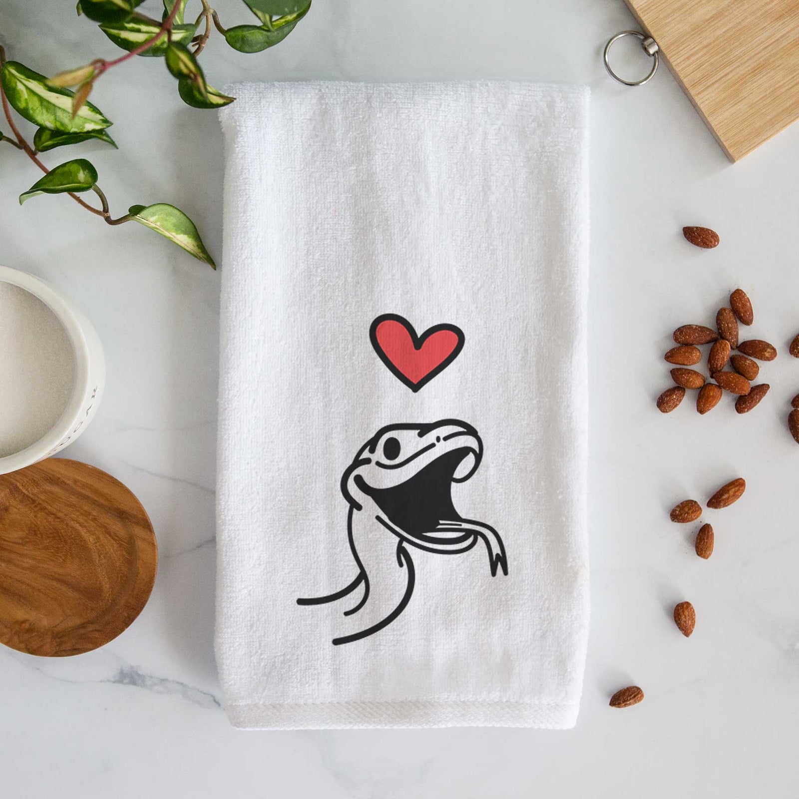 Minimalist line drawing of Spike the Snake with a red heart on a decorative hand towel