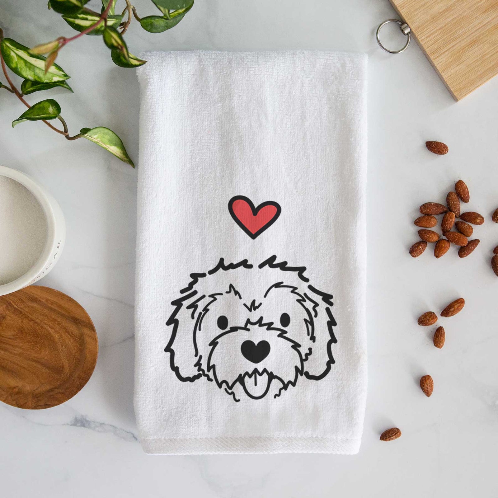 Minimalist line drawing of Sprinkles the Cockapoo with a red heart on a decorative hand towel