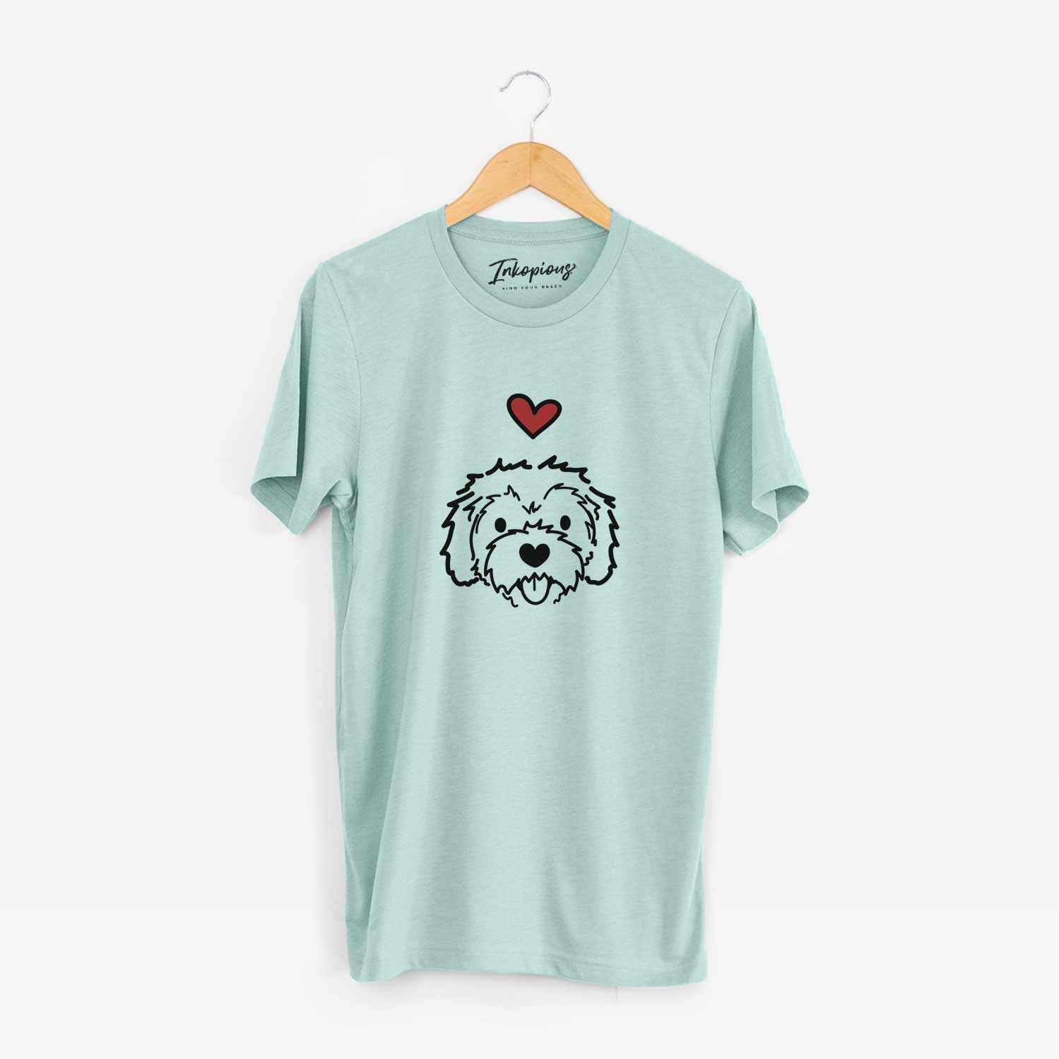Minimalist line drawing of Sprinkles the Cockapoo with a red heart on a Heather Sage Unisex crewneck