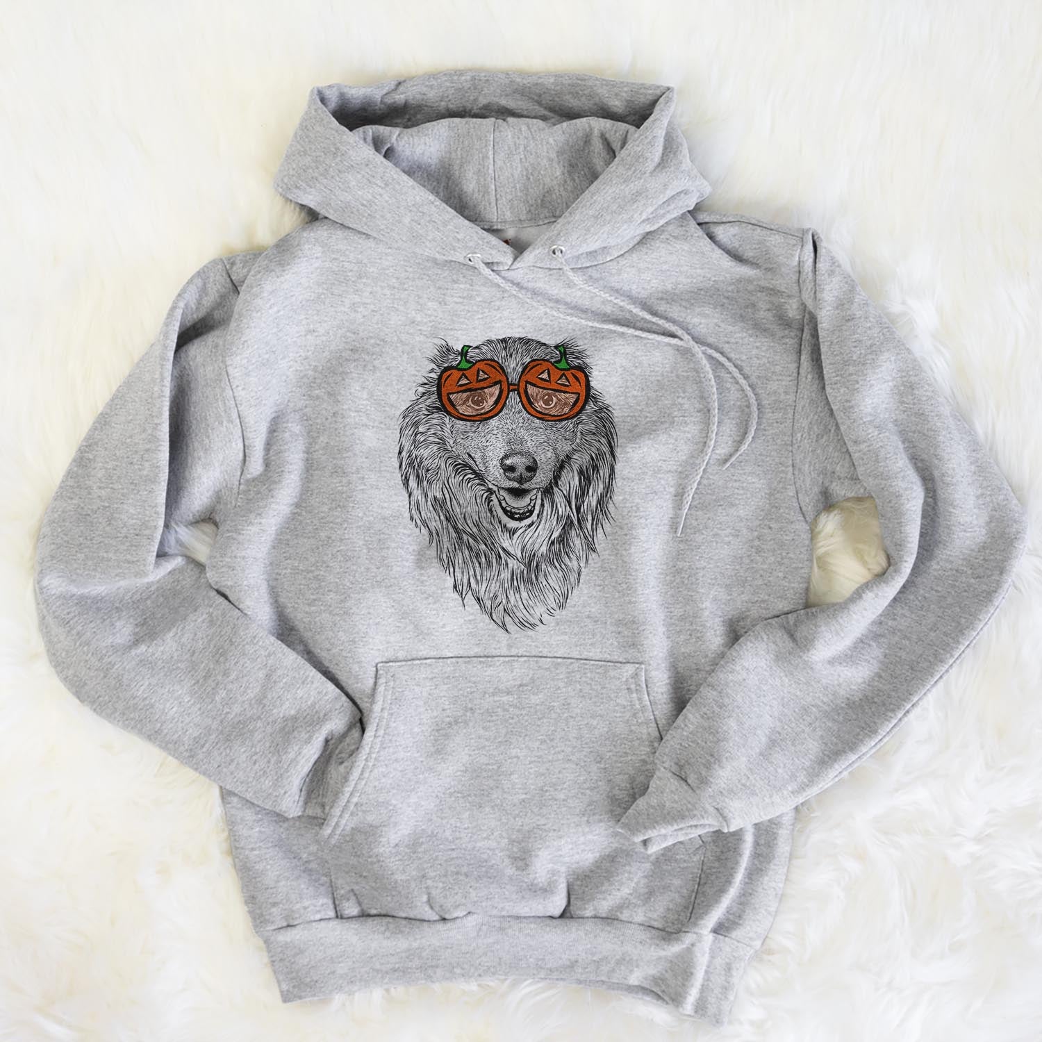 Hand-drawn sketch of Addie the Mixed Breed wearing pumpkin glasses on a Grey pumpkin collection, flat lay