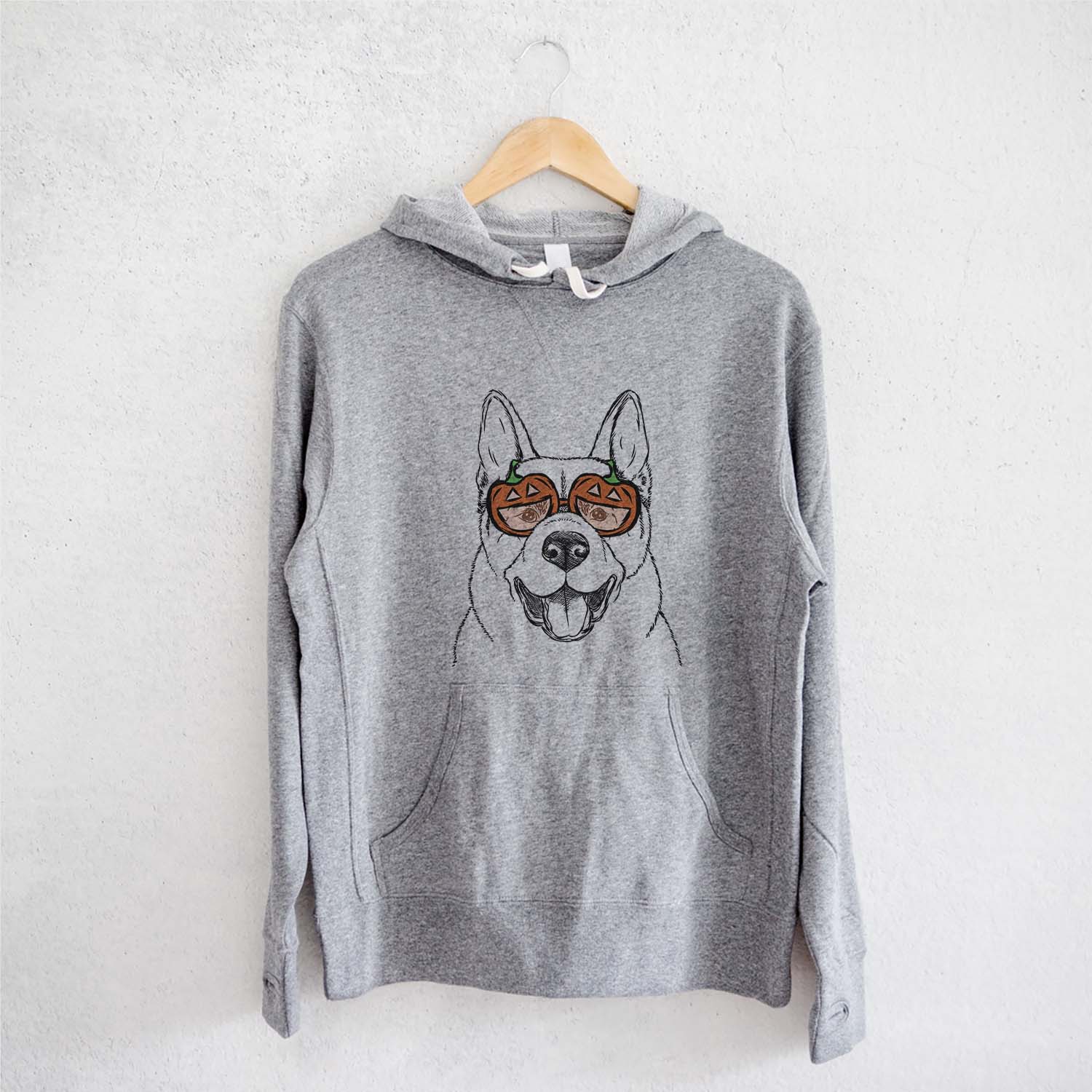 Hand-drawn sketch of Baku the Akita wearing pumpkin glasses on a Grey pumpkin collection, on a hanger