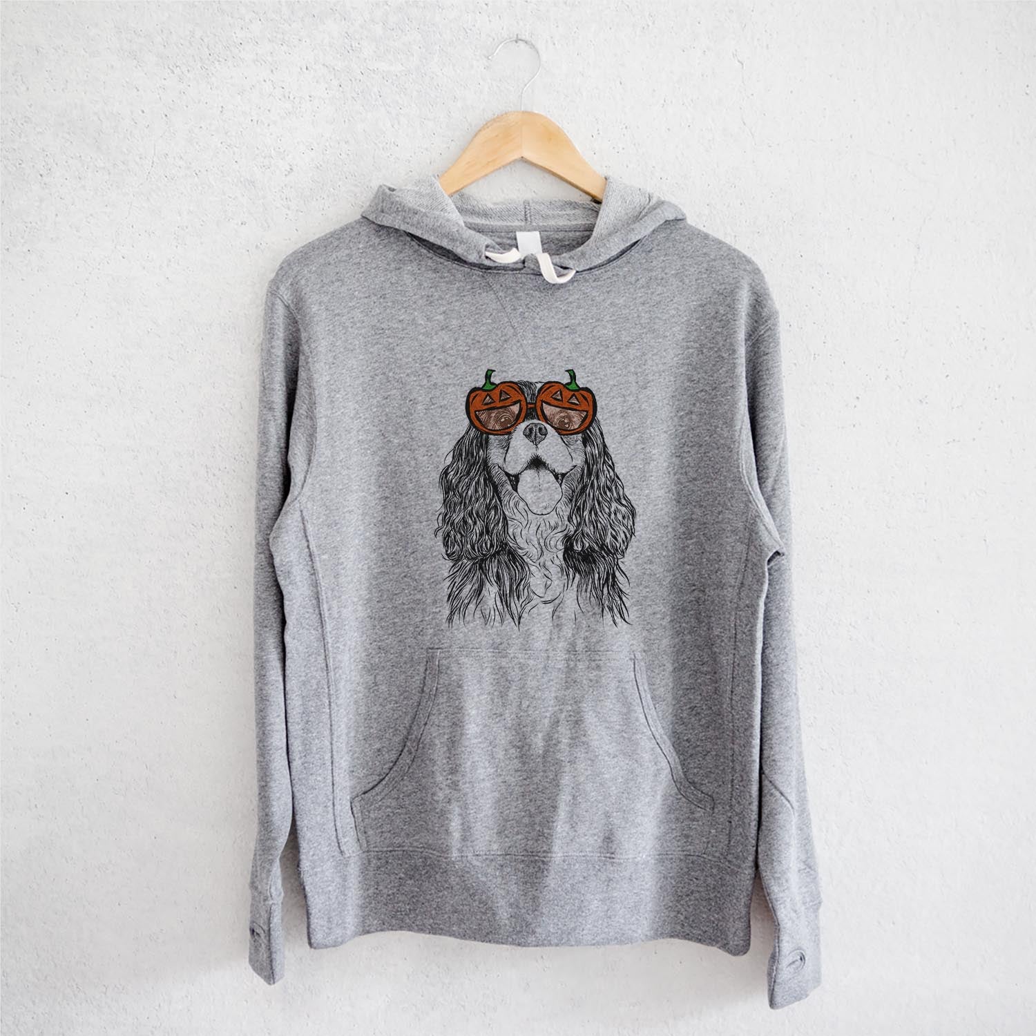 Hand-drawn sketch of Brandy the Cavalier King Charles Spaniel wearing pumpkin glasses on a Grey pumpkin collection, on a hanger