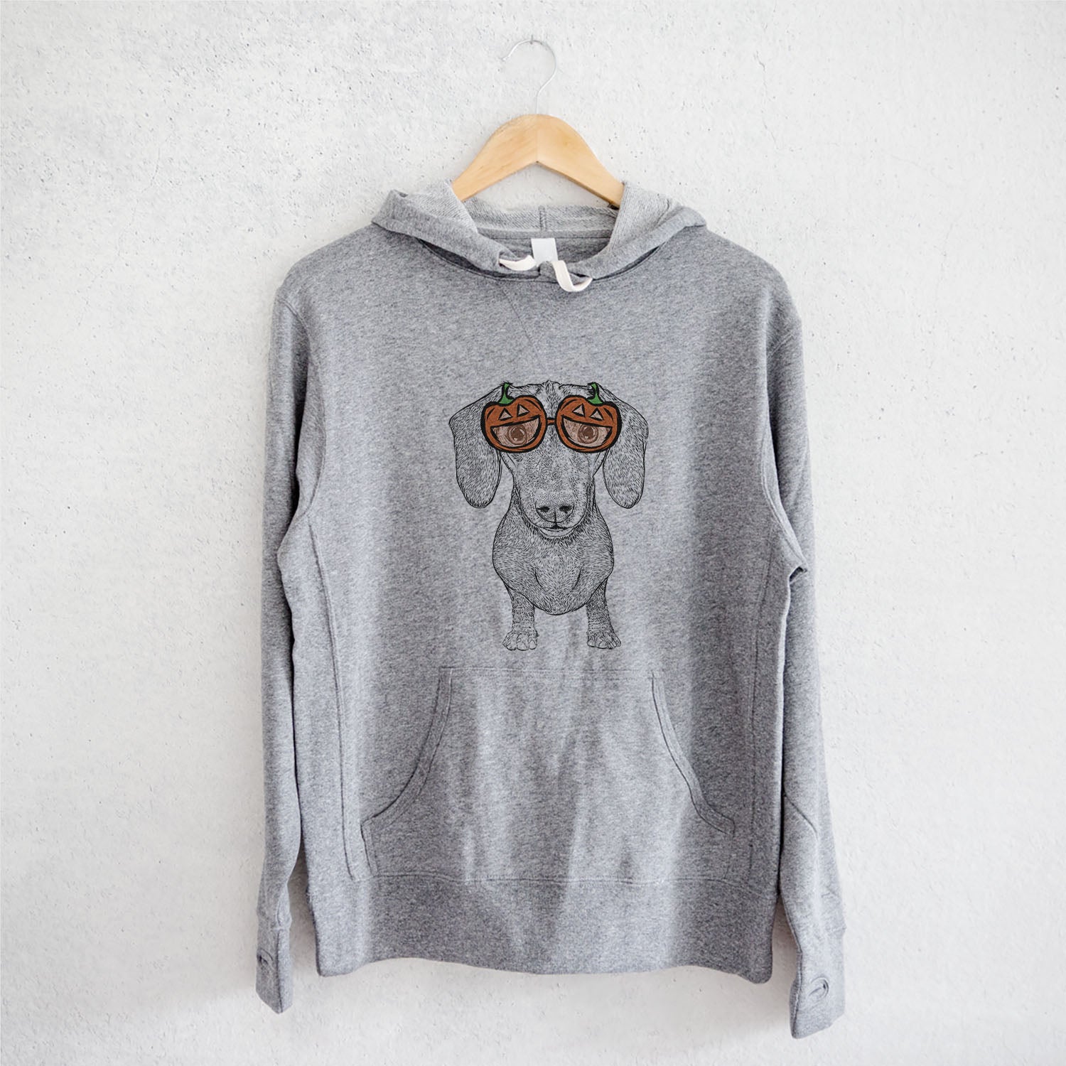 Hand-drawn sketch of Ernie the Mini Dachshund wearing pumpkin glasses on a Grey pumpkin collection, on a hanger