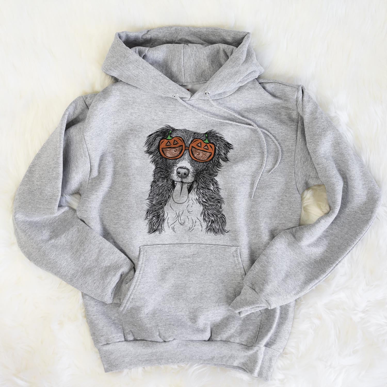 Hand-drawn sketch of Indi the Border Collie wearing pumpkin glasses on a Grey pumpkin collection, flat lay