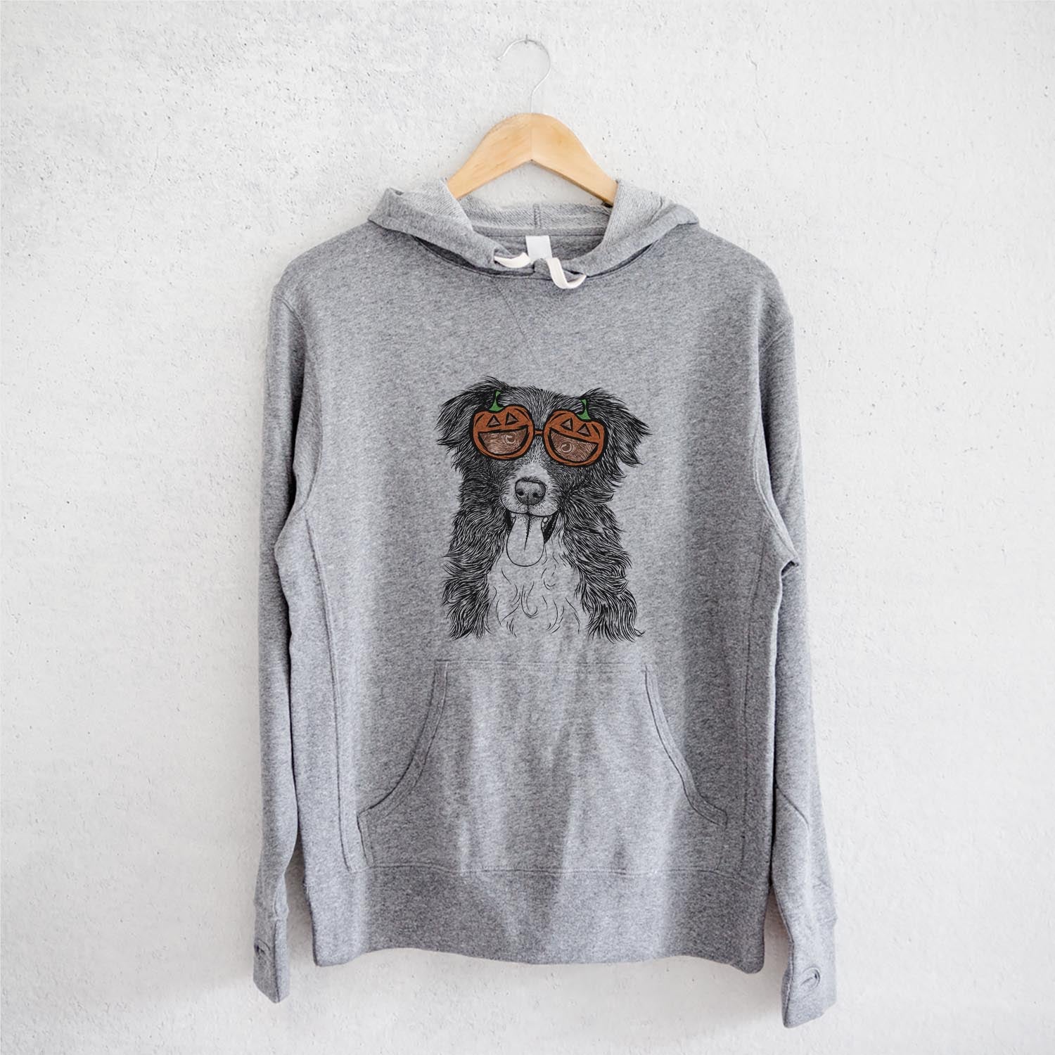 Hand-drawn sketch of Indi the Border Collie wearing pumpkin glasses on a Grey pumpkin collection, on a hanger
