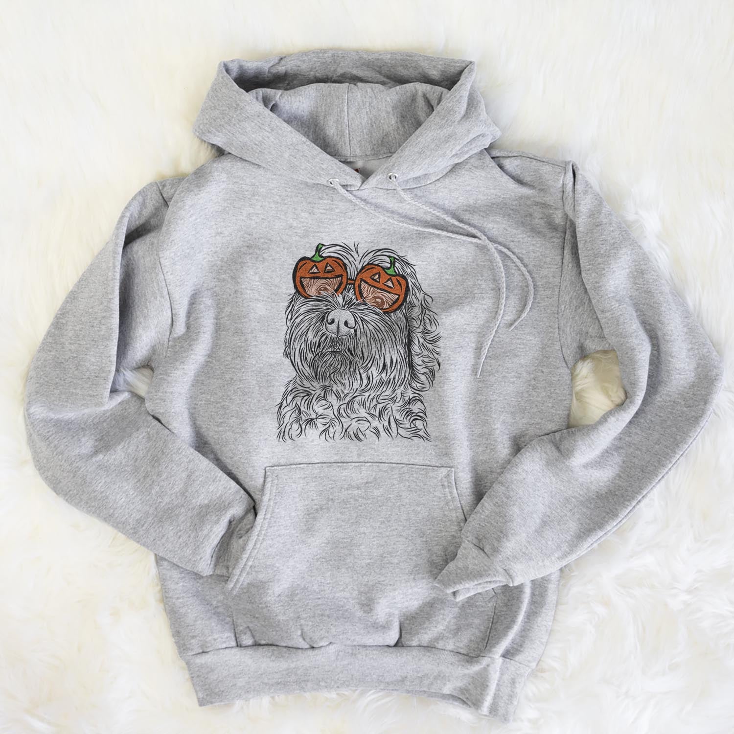Hand-drawn sketch of Maggie Girl the Cockapoo wearing pumpkin glasses on a Grey pumpkin collection, flat lay