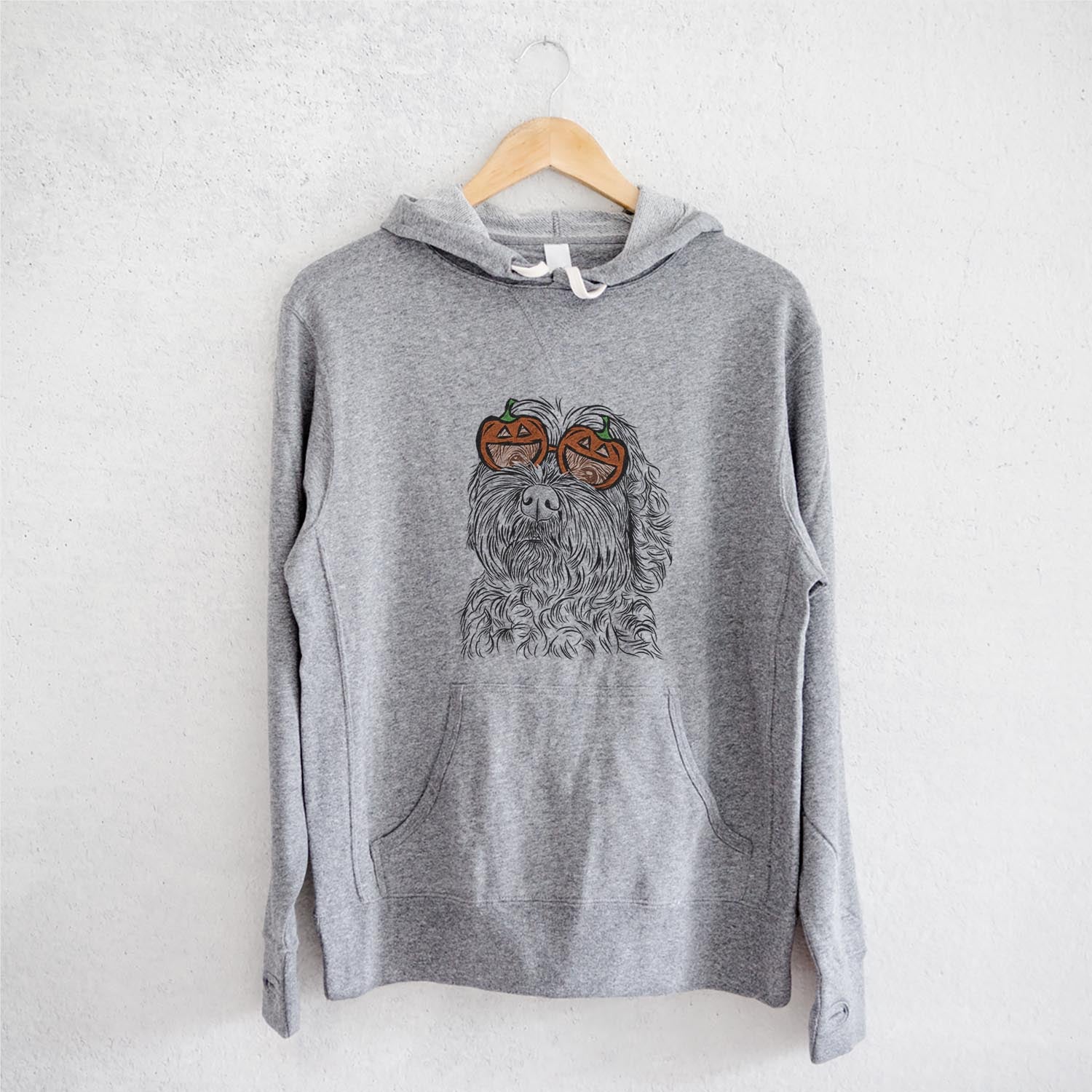 Hand-drawn sketch of Maggie Girl the Cockapoo wearing pumpkin glasses on a Grey pumpkin collection, on a hanger