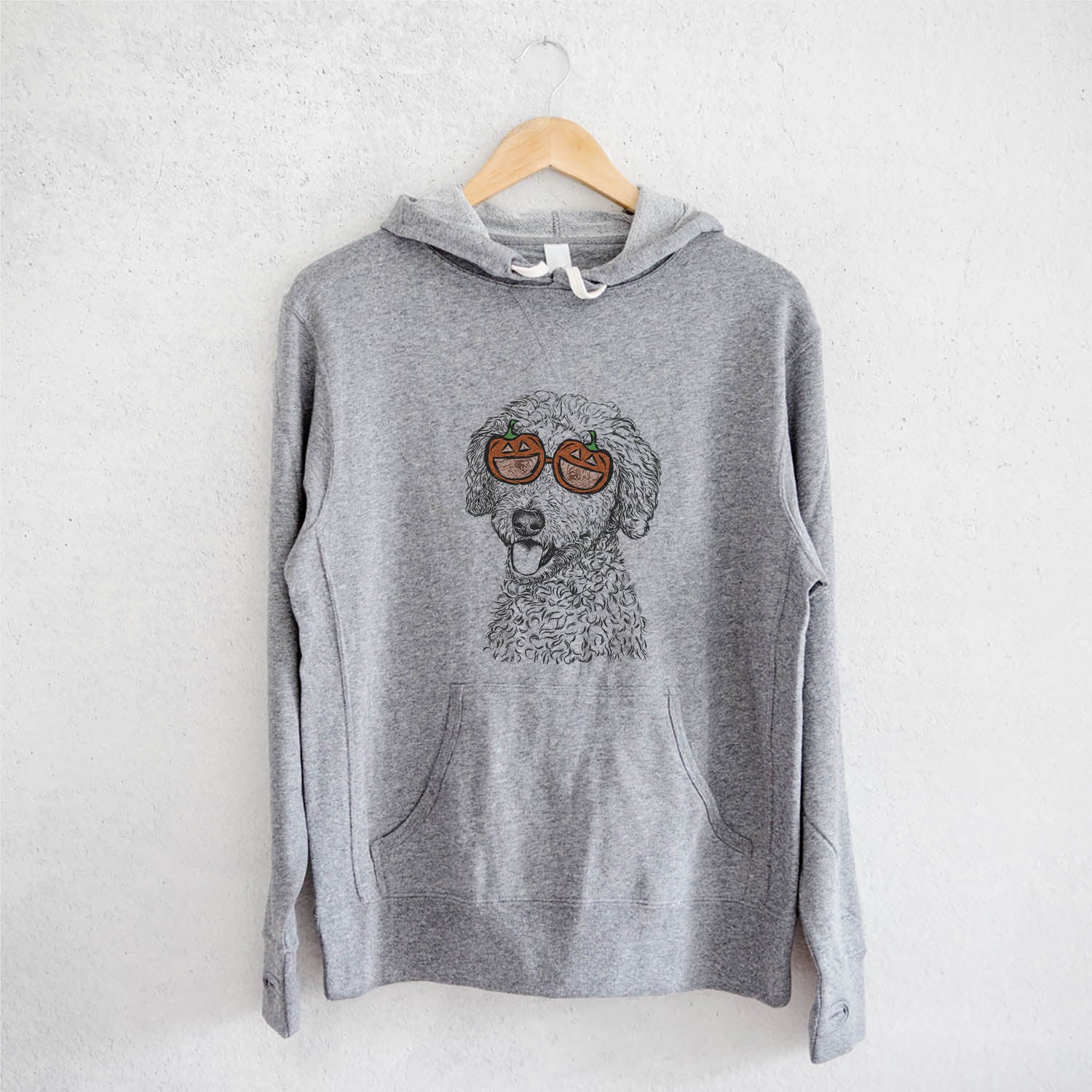 Hand-drawn sketch of Marlow the Goldendoodle wearing pumpkin glasses on a Marlow Doodle pumpkin collection, on a hanger