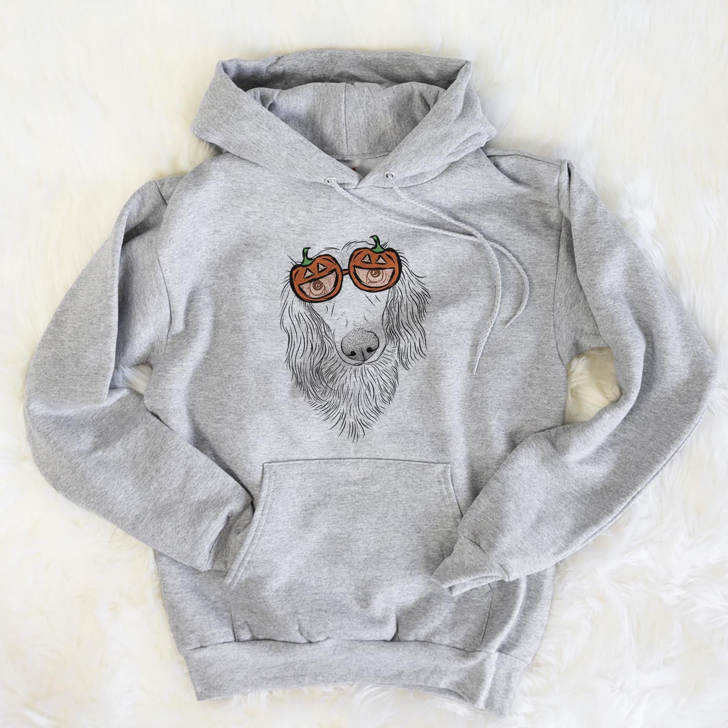 Hand-drawn sketch of Mr. Rusty the Long Haired Dachshund wearing pumpkin glasses on a Mr Rusty pumpkin collection, flat lay