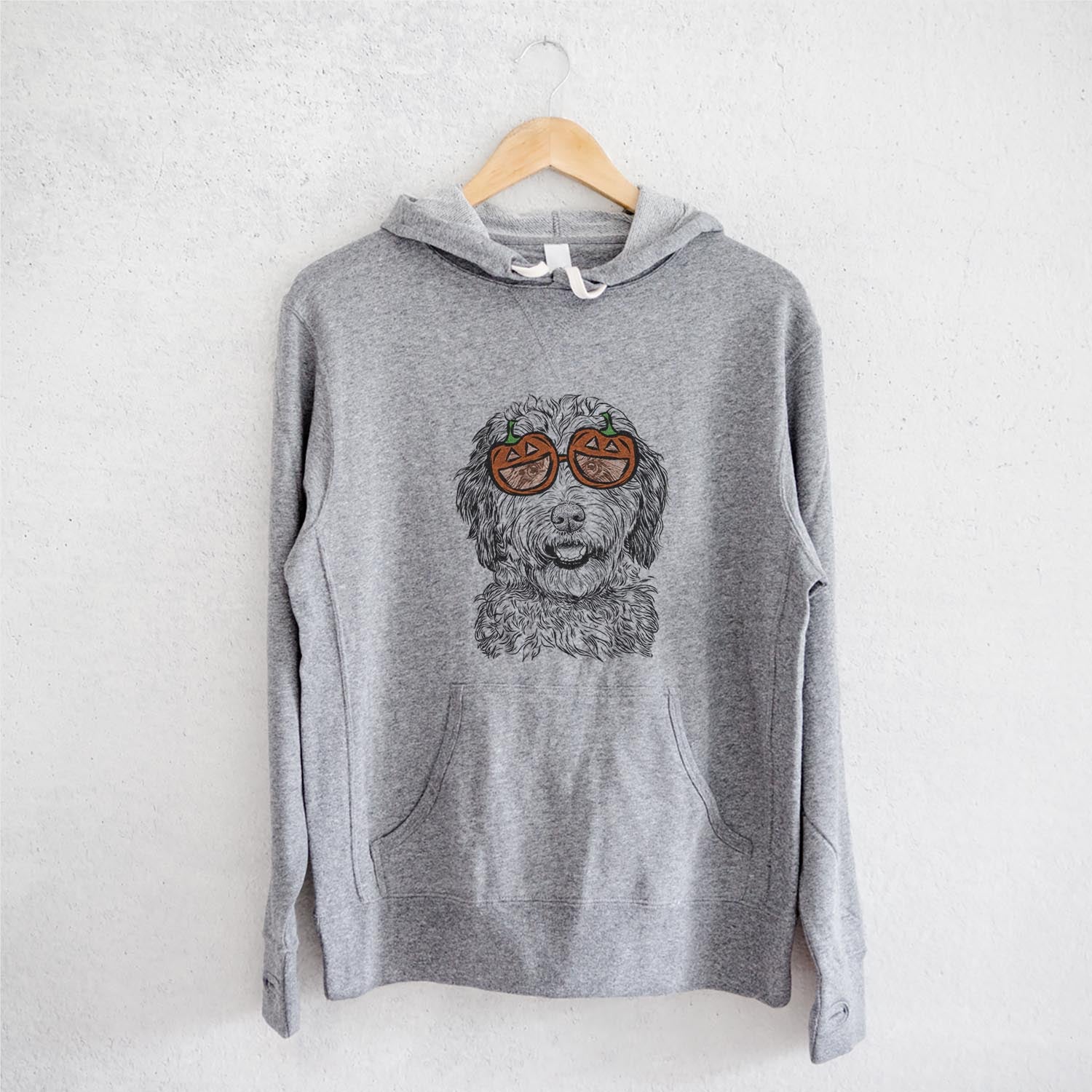 Hand-drawn sketch of Palmer the Aussiedoodle wearing pumpkin glasses on a Palmer Doodle pumpkin collection, on a hanger