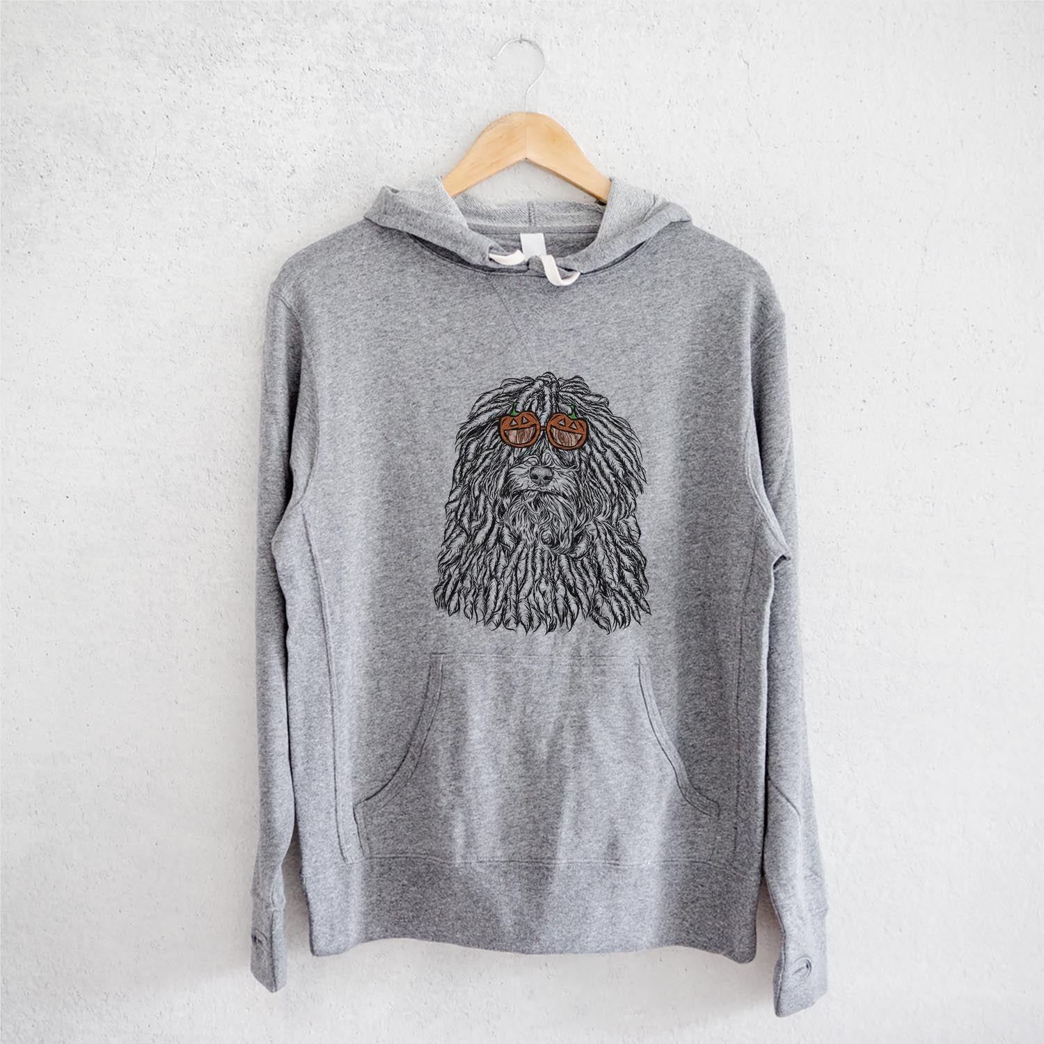 Hand-drawn sketch of Rezi the Puli wearing pumpkin glasses on a Grey pumpkin collection, on a hanger
