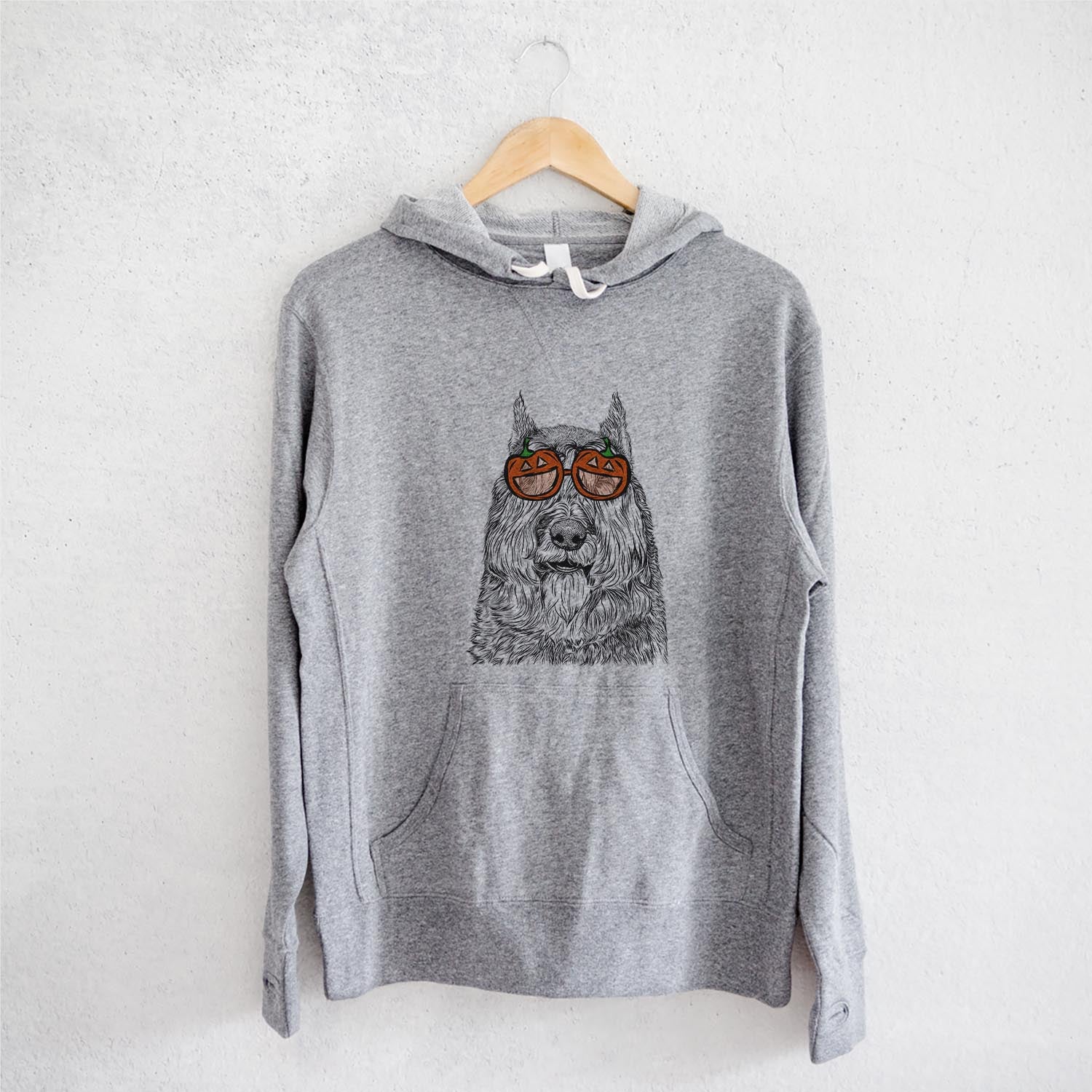 Hand-drawn sketch of Sabre the Bouvier des Flandres wearing pumpkin glasses on a Grey pumpkin collection, on a hanger
