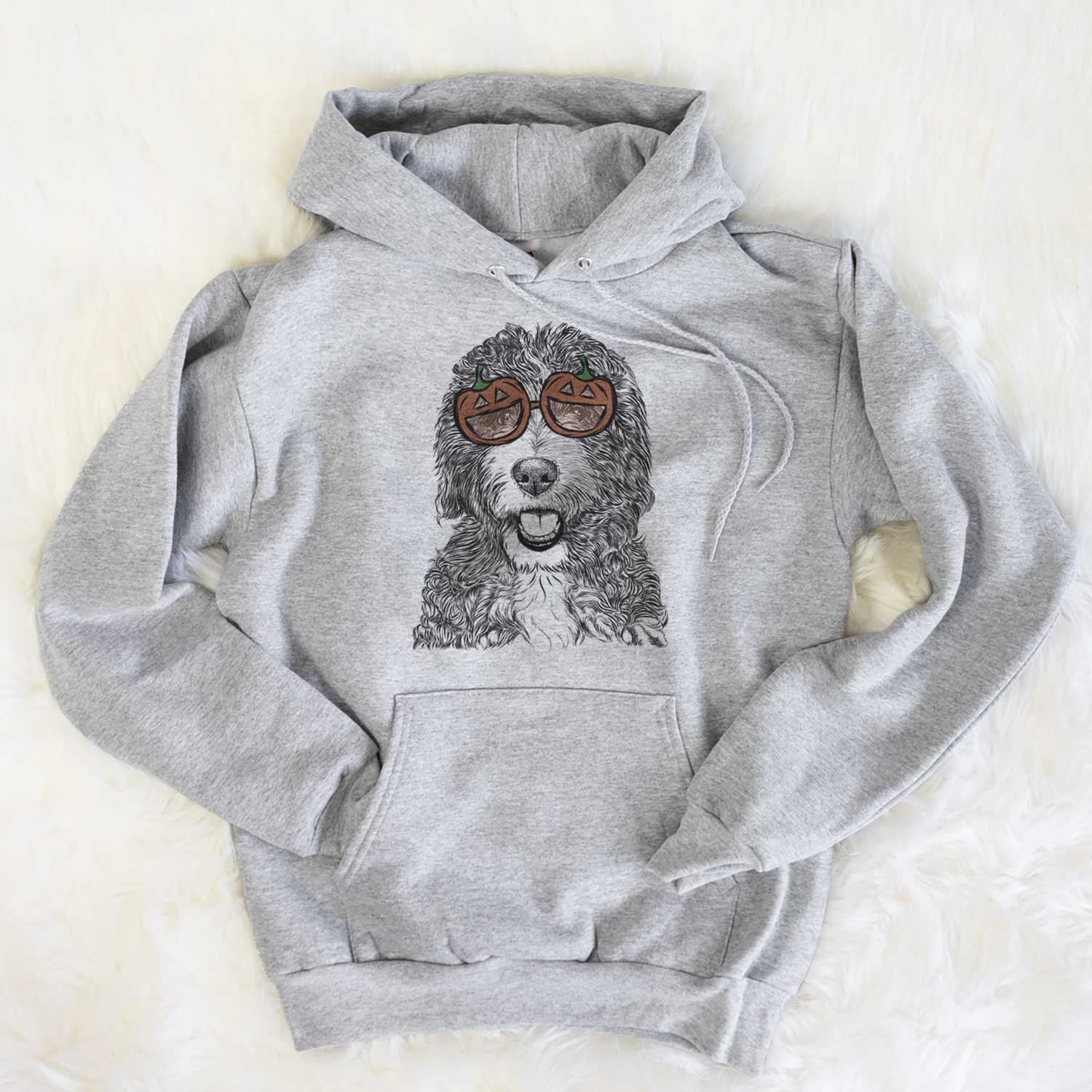 Hand-drawn sketch of Bash the Bernedoodle wearing pumpkin glasses on a Grey pumpkin collection, flat lay