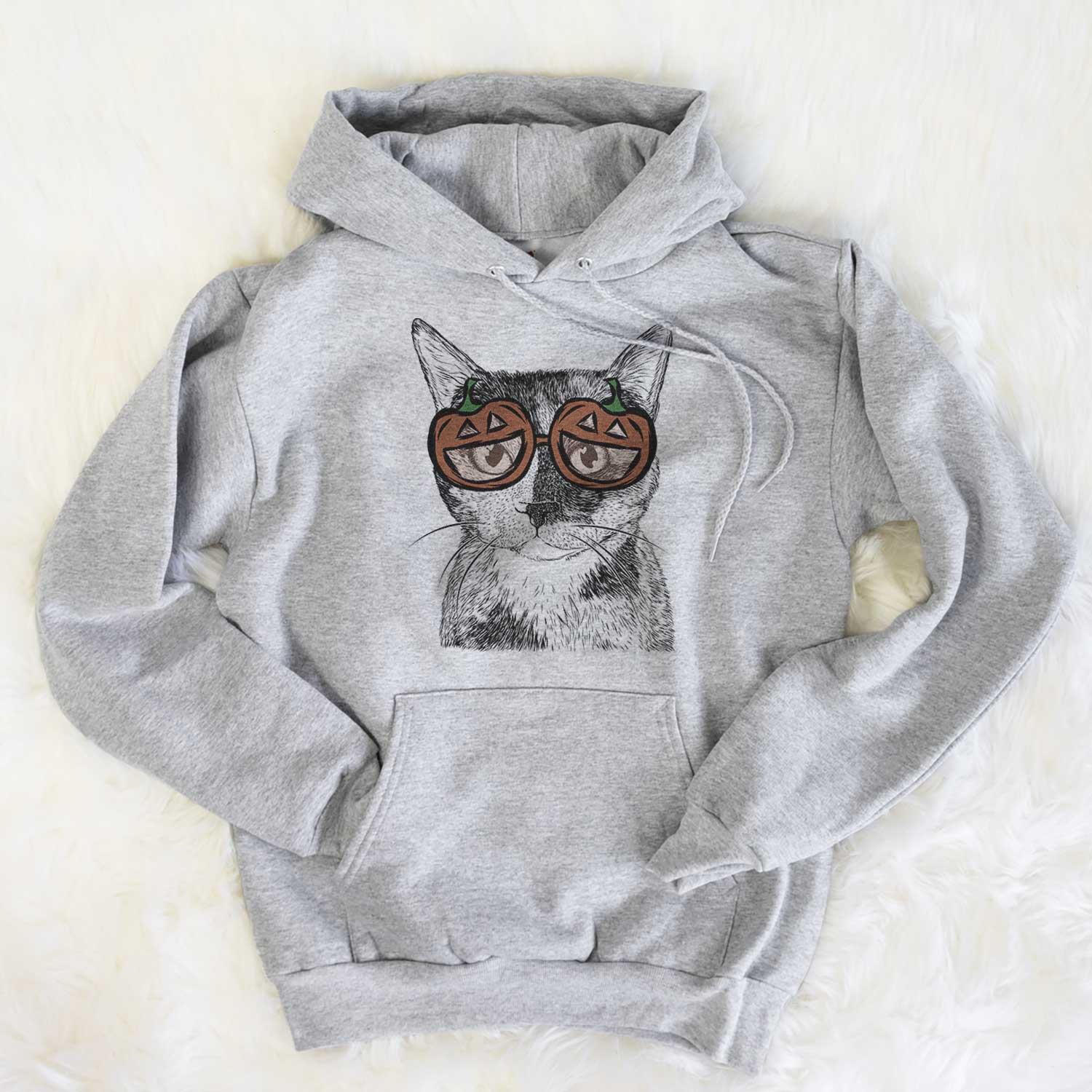 Hand-drawn sketch of Spooky Kitty the Tortoiseshell Cat wearing pumpkin glasses on a Grey pumpkin collection, flat lay
