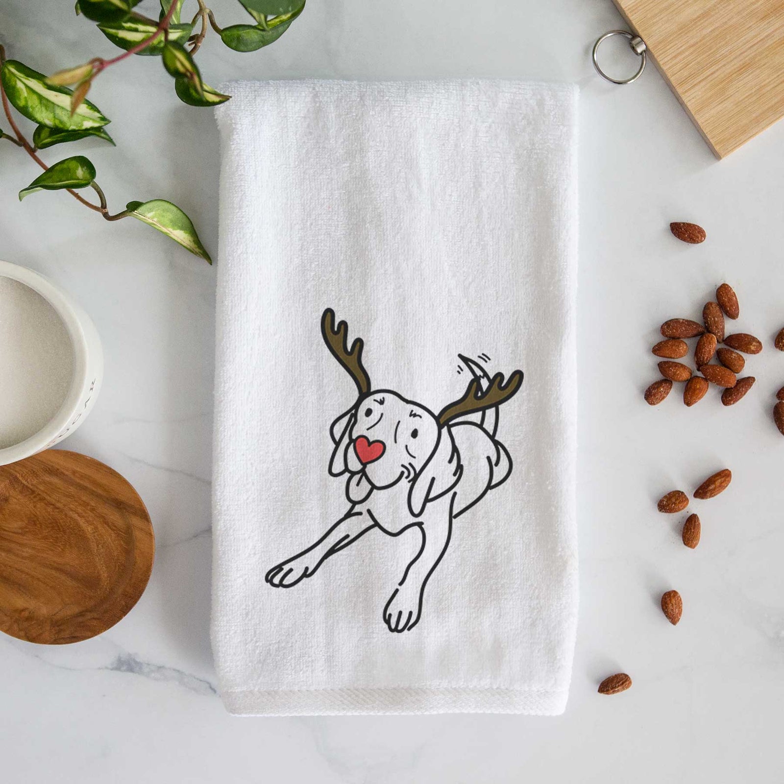Minimalist line drawing of Bagel the Beagle with reindeer antlers and a red nose on a decorative hand towel