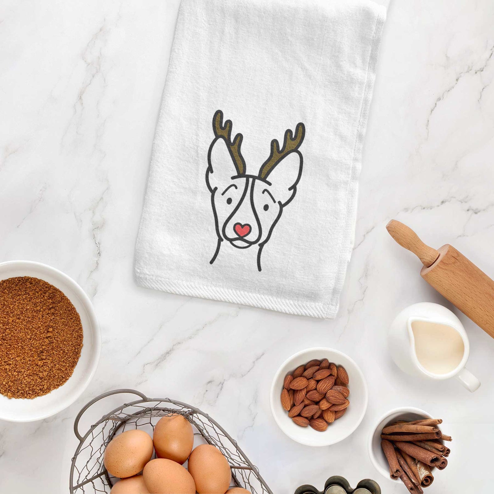 Minimalist line drawing of a Basenji with reindeer antlers and a red nose on a decorative hand towel