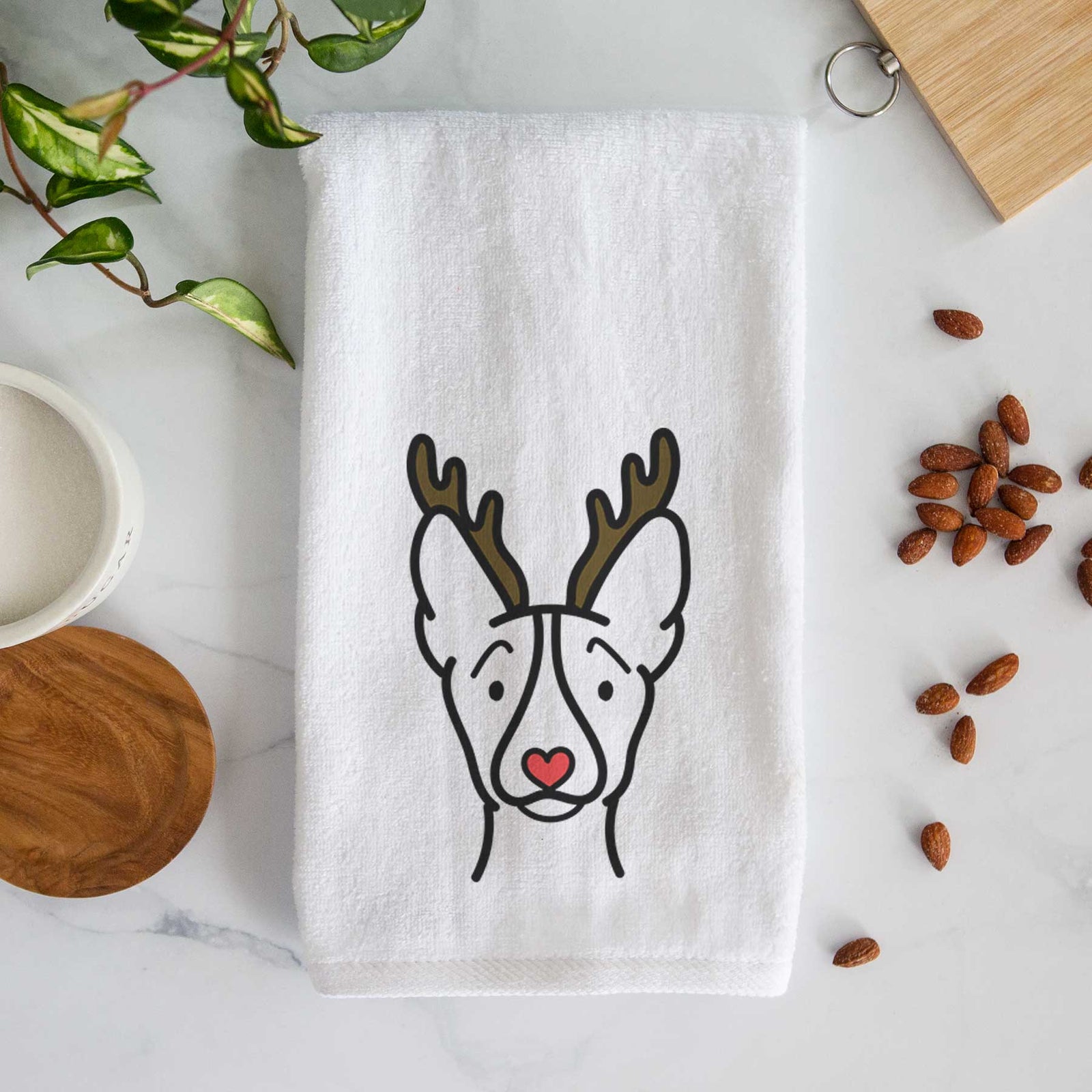 Minimalist line drawing of a Basenji with reindeer antlers and a red nose on a decorative hand towel